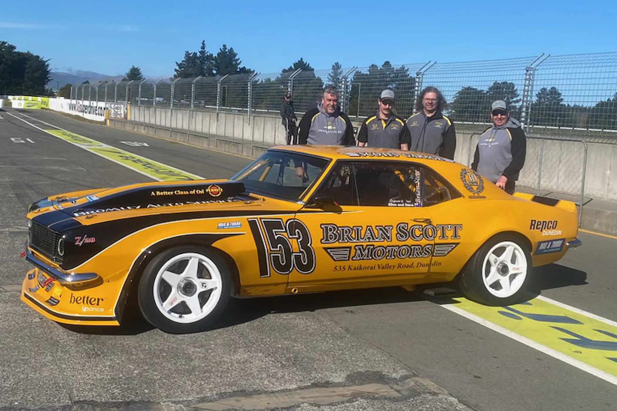 Soon to sail . . . The Brian Scott team with driver Rob Lewis (left) with the Chev Camaro as they prepare it for its sea journey across the Tasman to race at Bathurst early in October. Photo: Supplied