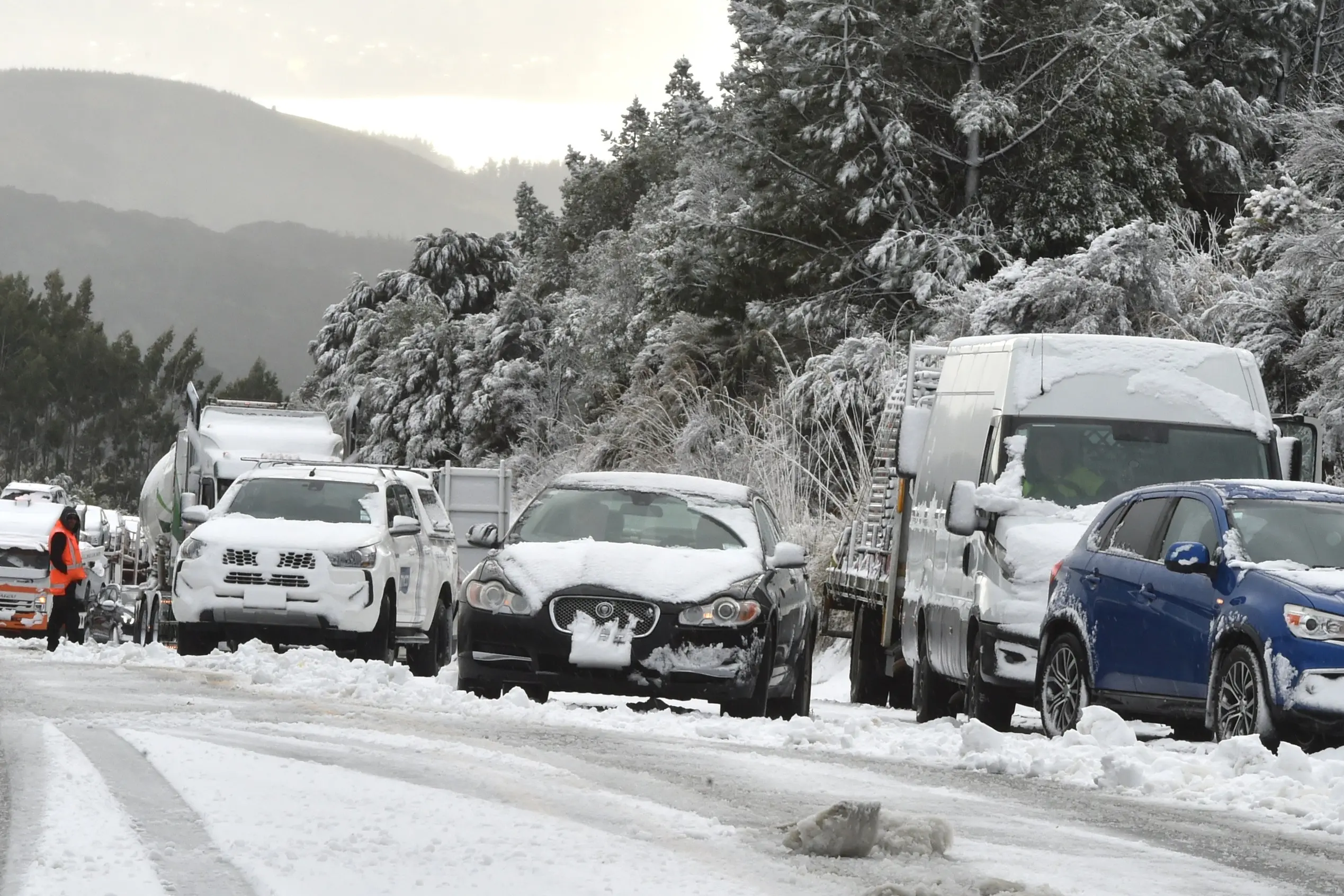 Vehicles stuck in snow near the top of the Leith Saddle, on State Highway 1, between Dunedin and Waitati on Monday. Photo: Gregor Richardson