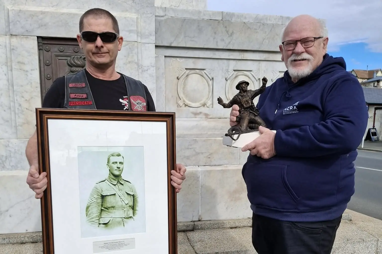 New Zealand Remembrance Army (NZRA) Waitaki co-ordinator Barry Gamble (right) with a maquette for the proposed statue of Sergeant Donald Forrester Brown VC stands with Patriots Force Motorcycle Club Deep South chapter president Azza Wood, holding a historic photograph of Sgt Brown, at a presentation at the Oamaru War Memorial in Thames St. Photo: Supplied.