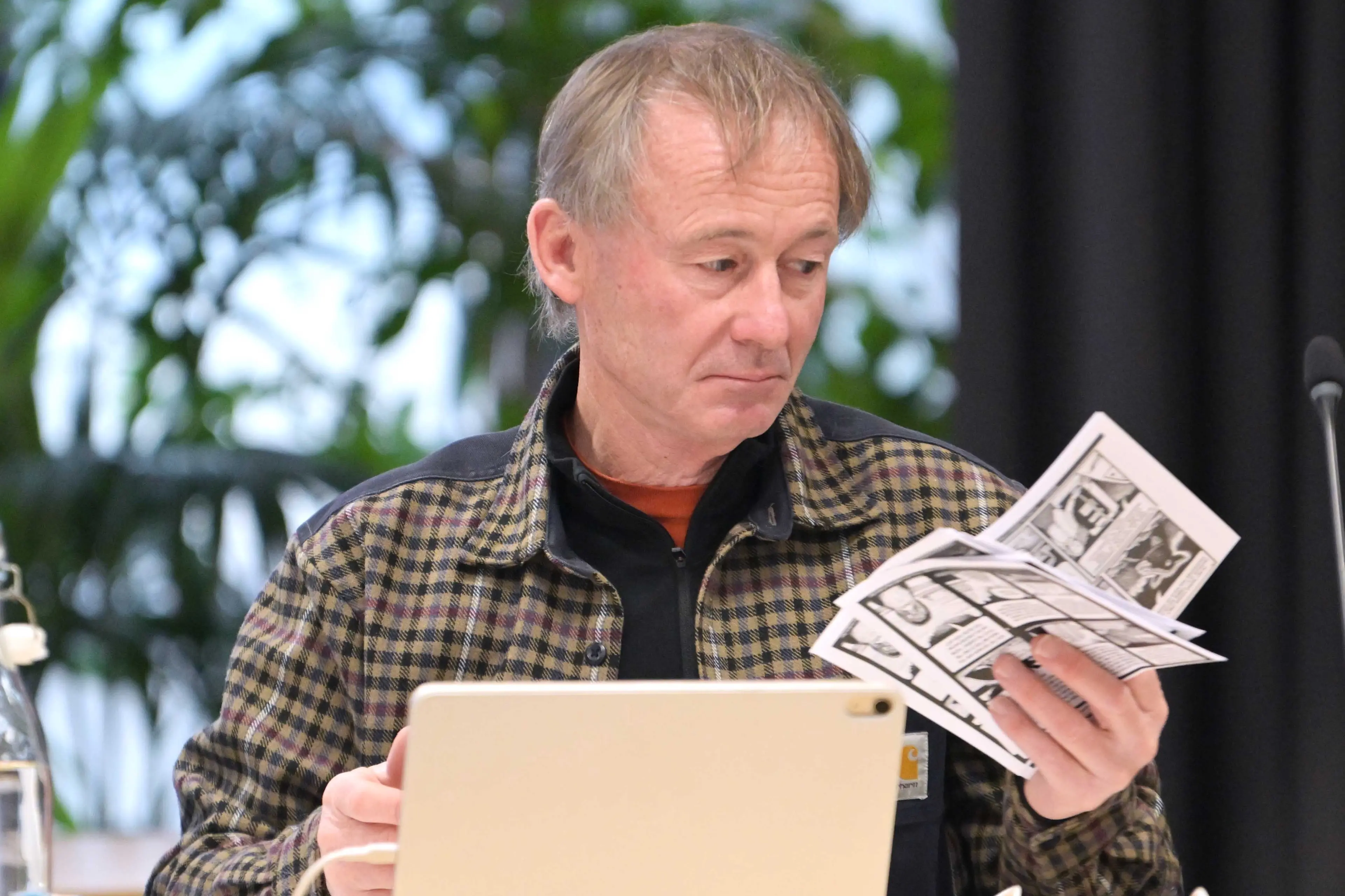 Cr Russell Lund considers a pile of comics presented by artist and climate activist Bruce Mahalski during the Dunedin City Council public forum yesterday. Photo: Gerard O\\'Brien