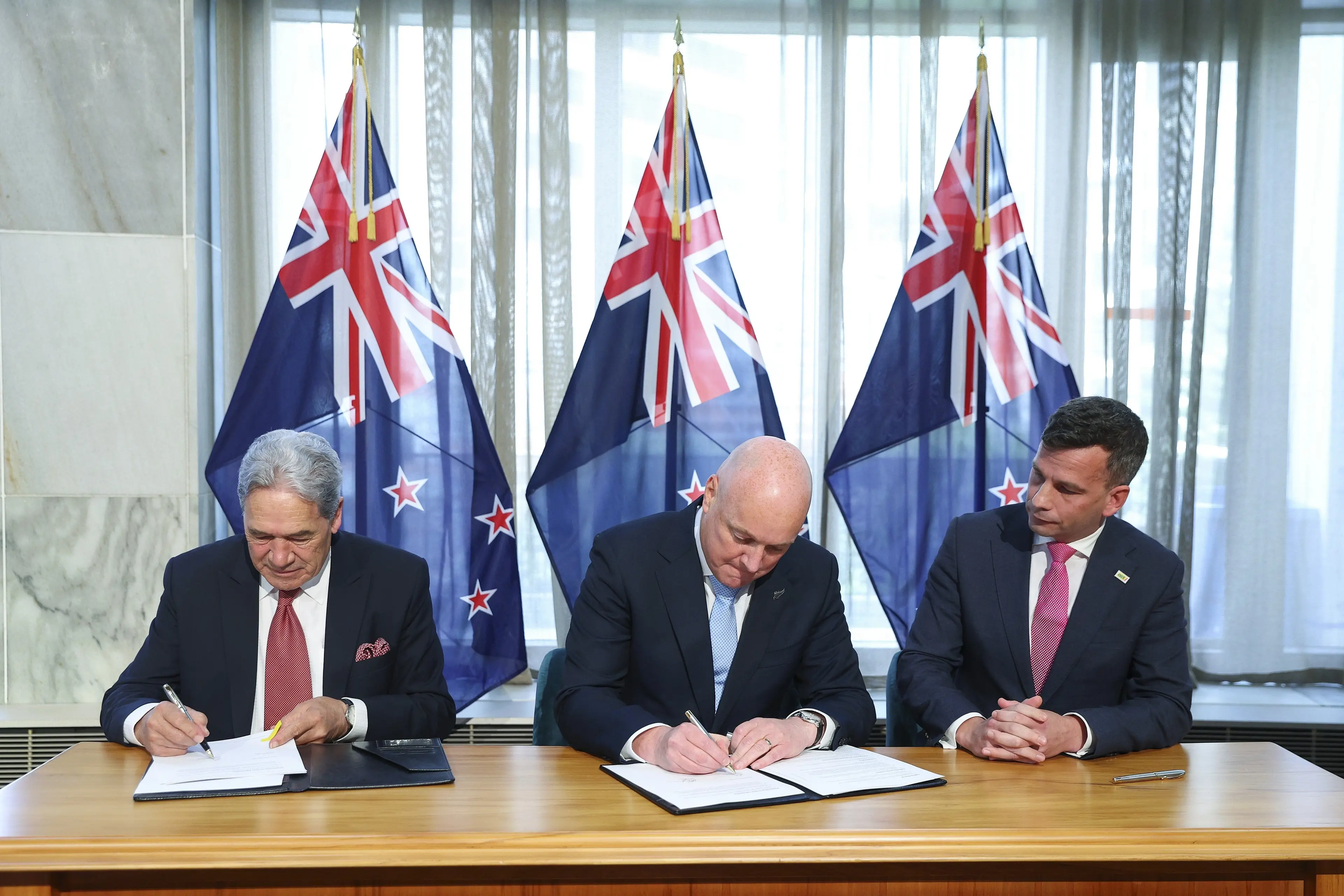 Read carefully before signing: New Zealand First leader Winston Peters, National leader Christopher Luxon and Act New Zealand leader David Seymour sign their coalition agreement in 2023.  Photo: Getty Images)
