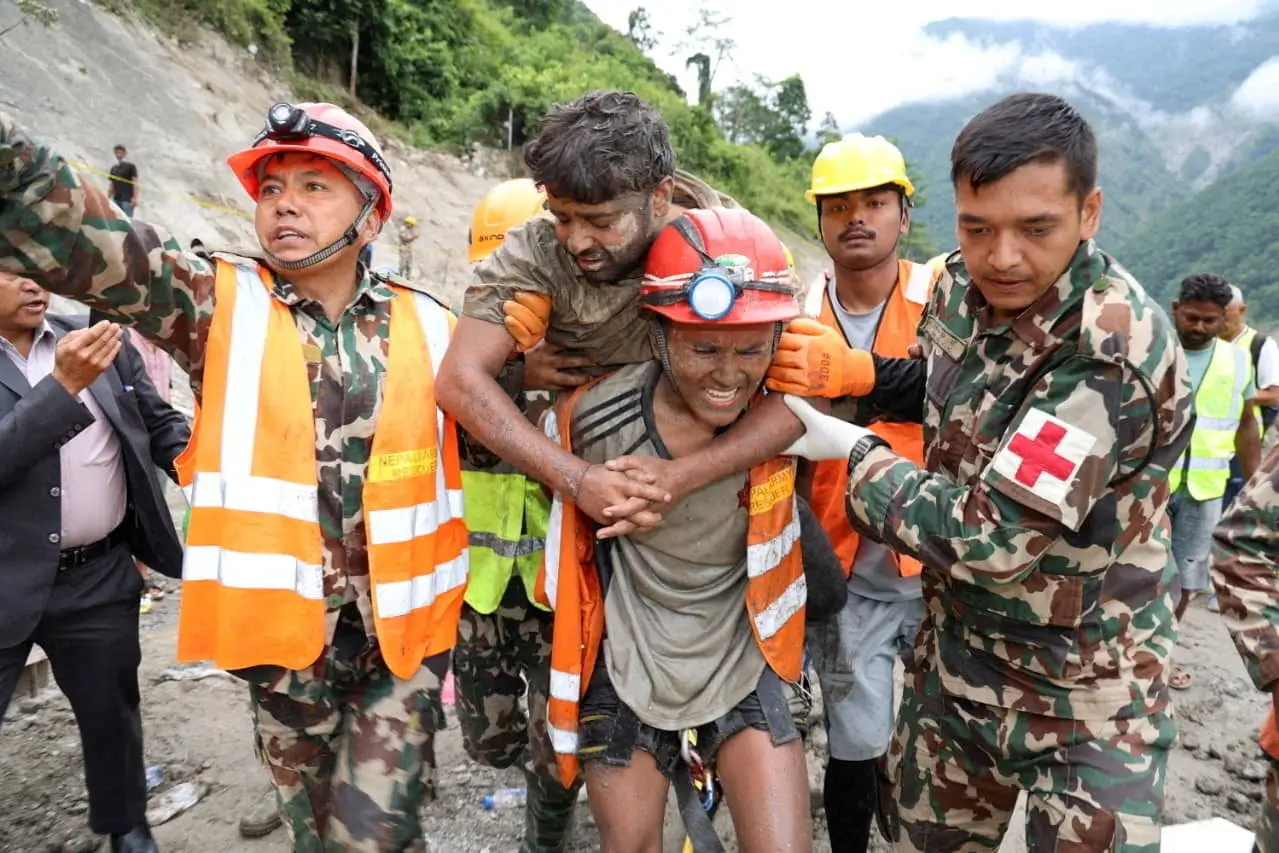 Sanjay Sah is carried by members of a search and rescue team after being one of two people rescued alive from a tunnel at the Trishuli-3A Hydropower Project, where two people had been trapped for nine days following devastating floods and mudslides that struck the Bhotekoshi River in Rasuwa, Nepal. Nepal Army/Handout via REUTERS