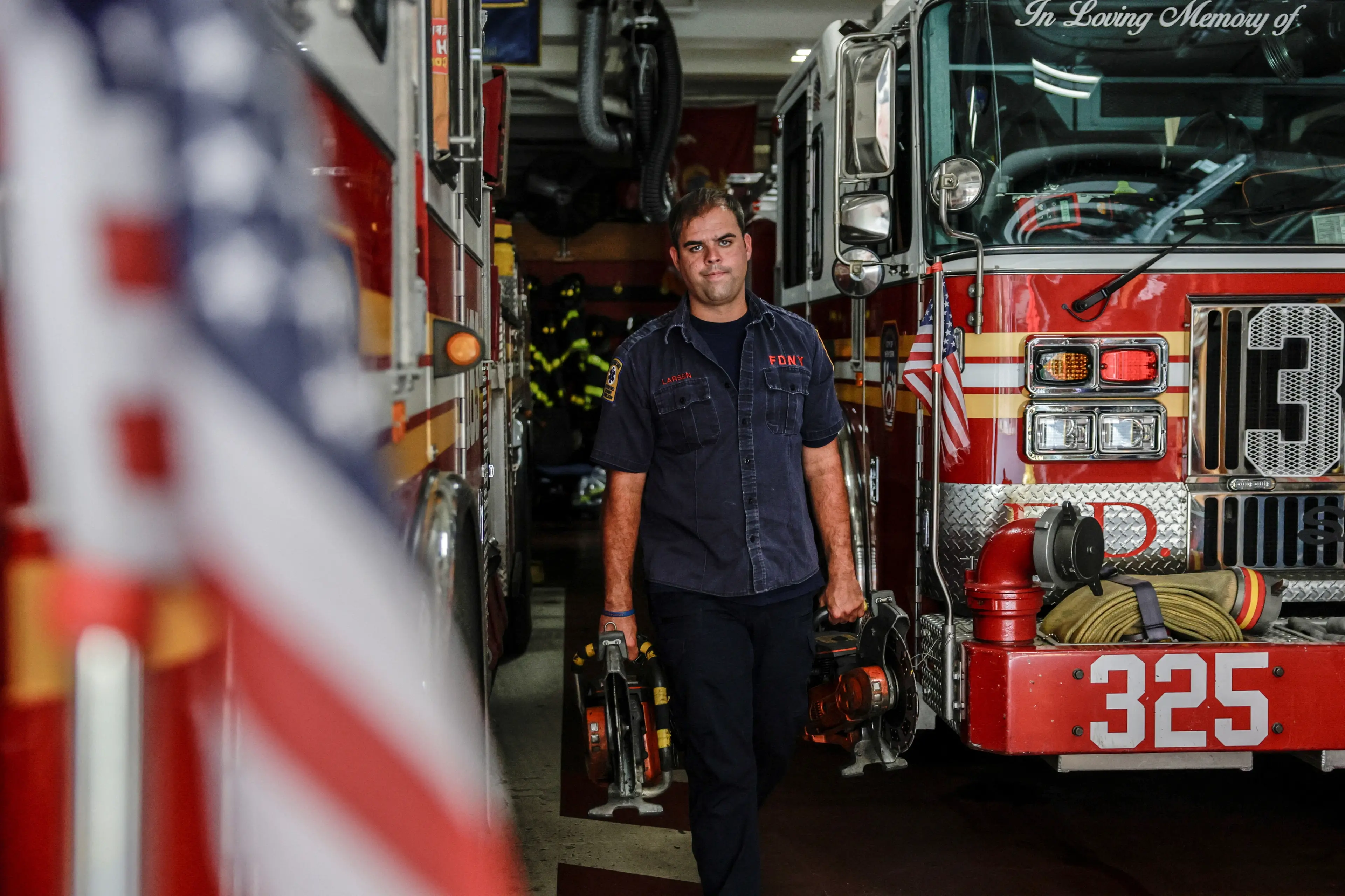 FDNY member Scott Larsen carries equipment where his father served during the September 11 attacks, in the Woodside neighbourhood of Queens. Photo: Reuters