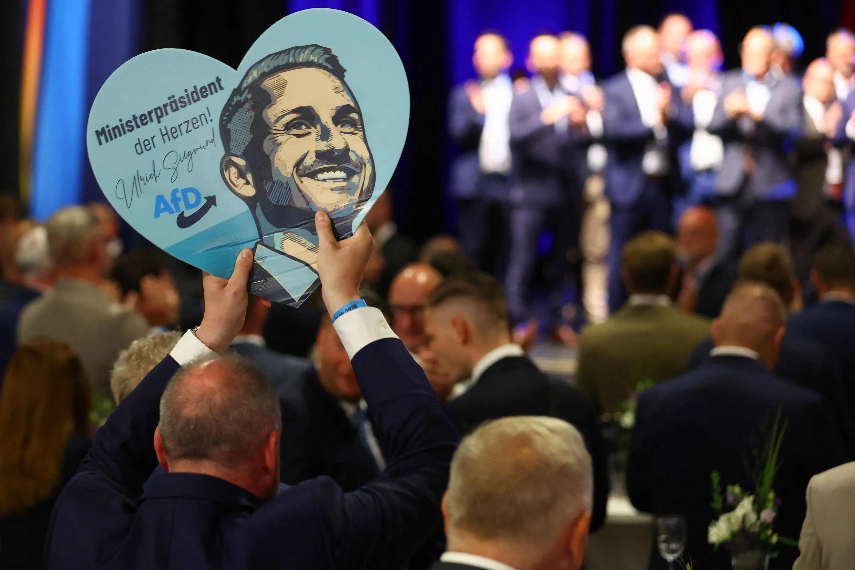 A supporter holds a sign with an image of top candidate of the far-right Alternative for Germany (AfD), Ulrich Siegmund, at the AfD election party. Photo: Reuters.