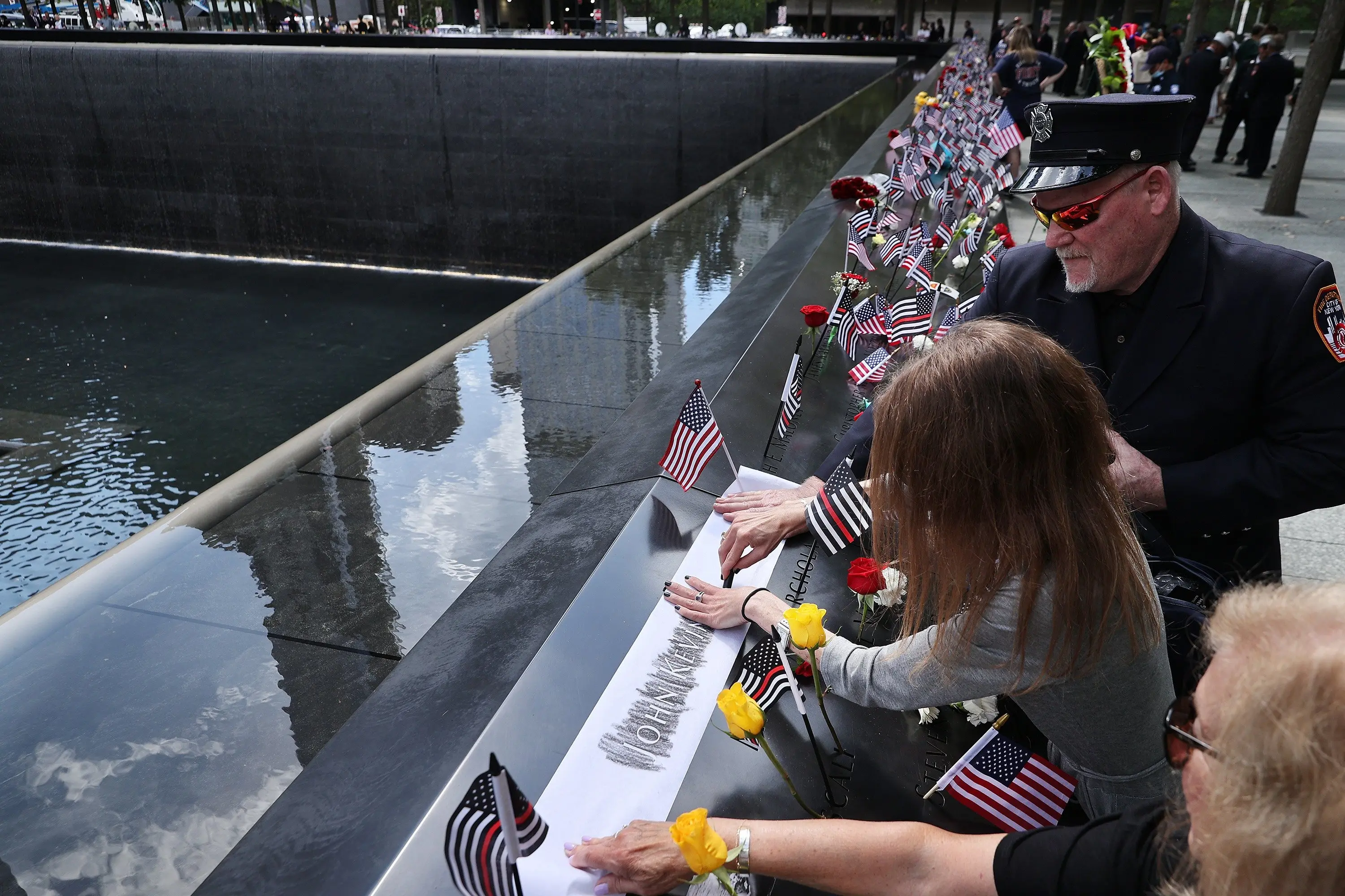 People make rubbings of the names of the victims of the 9/11 attacks and in the 1993 World Trade Centre bombing that are inscribed along the memorial pools at the National 9/11 Memorial. Photo: Getty Images