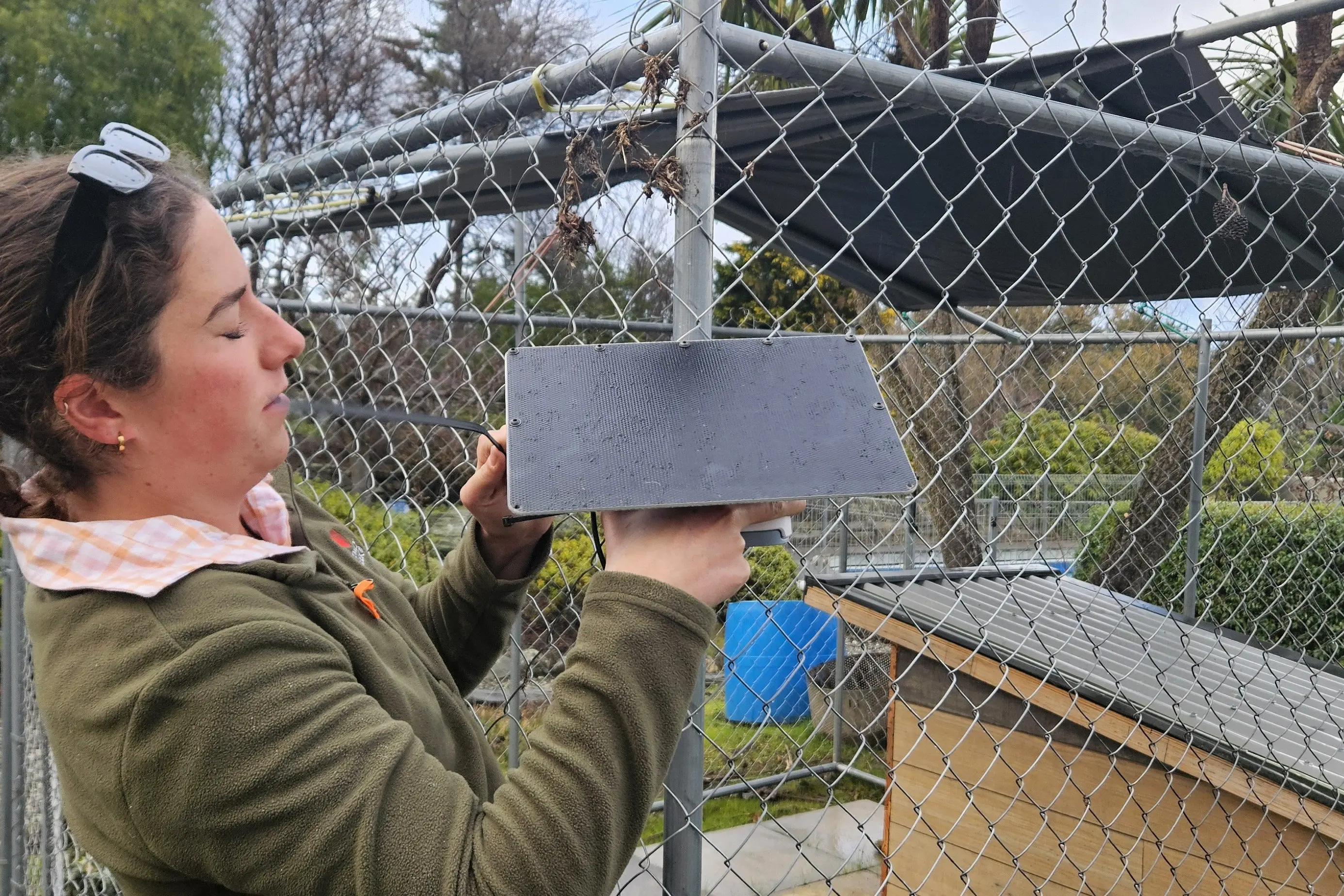 Local project volunteer Ella Gordon installs an outdoor air quality monitor at a participant\\'s home in H\\u0101wea.Photo: Supplied