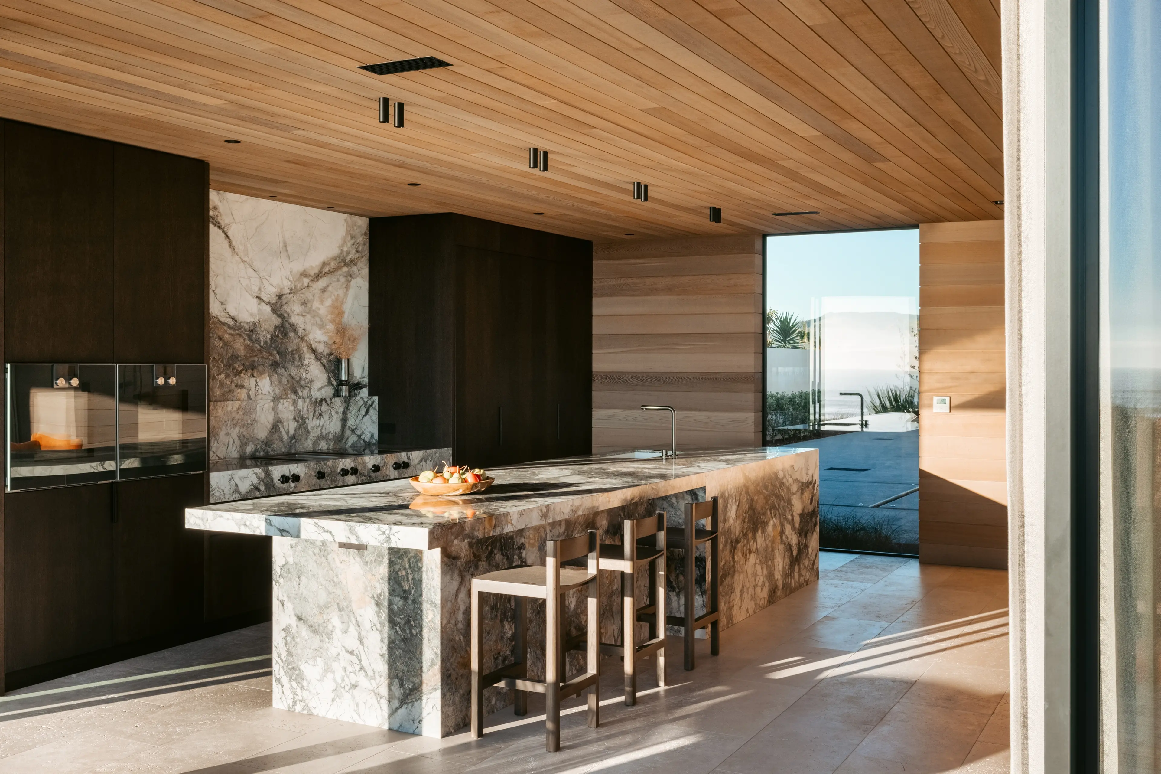 Designed to accommodate large gatherings, this kitchen in a Papamoa holiday home features a fully stone-clad island. It was the supreme kitchen runner-up at the National Kitchen and Bathroom Association awards. Design: Adam Spitz of Vekart. Photo: Boundless Vision