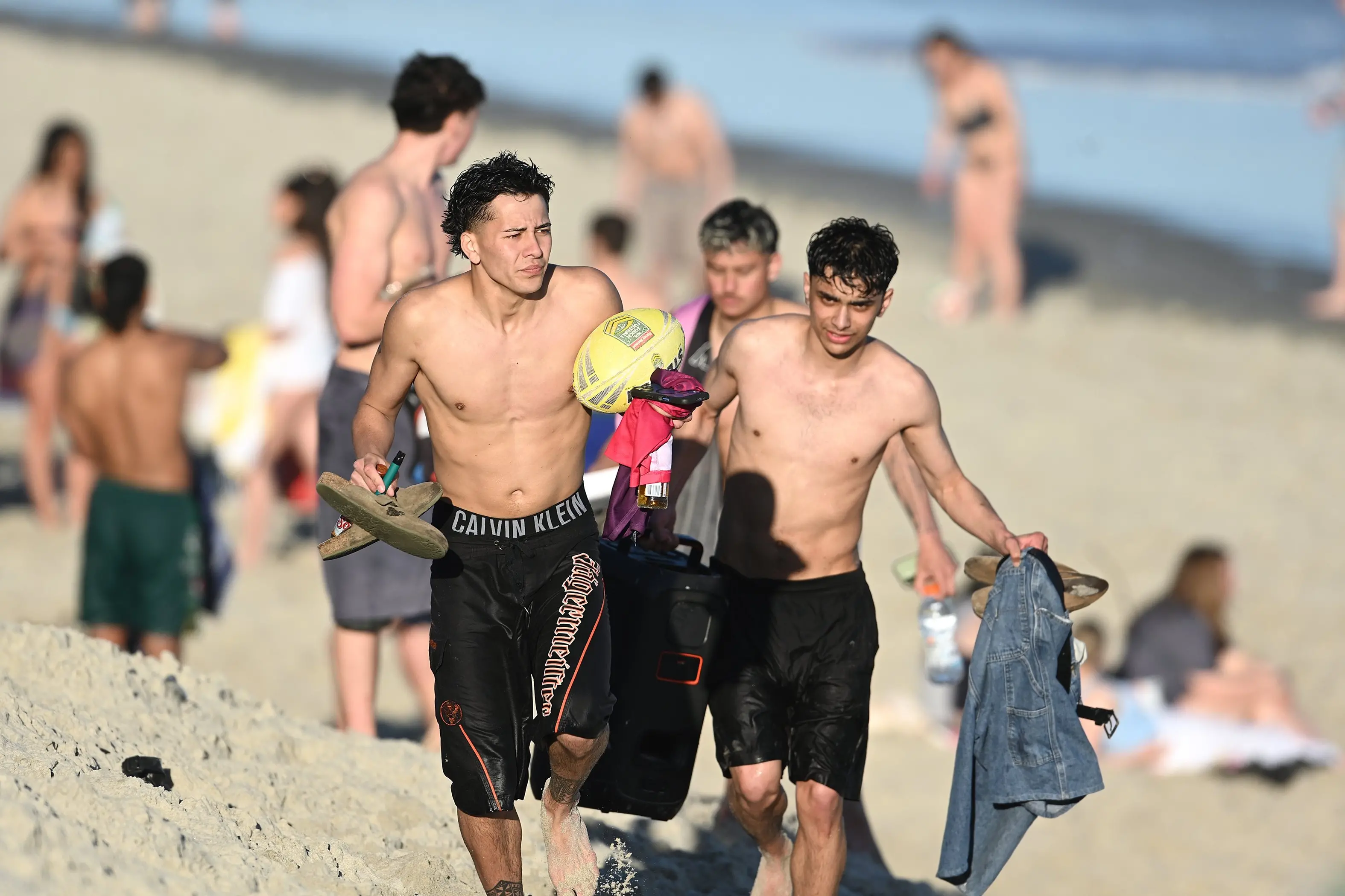 Dunedin barber Maximus Fatafehi (centre of photo), leads his student friends Deighton Collier (at rear) of Whakatane and Nelson Simpkins (right) of Rotorua back up the sand hill at St Kilda Beach after joining hundreds of other beach goers on an unseasonably hot spring day. Photo: Linda Robertson