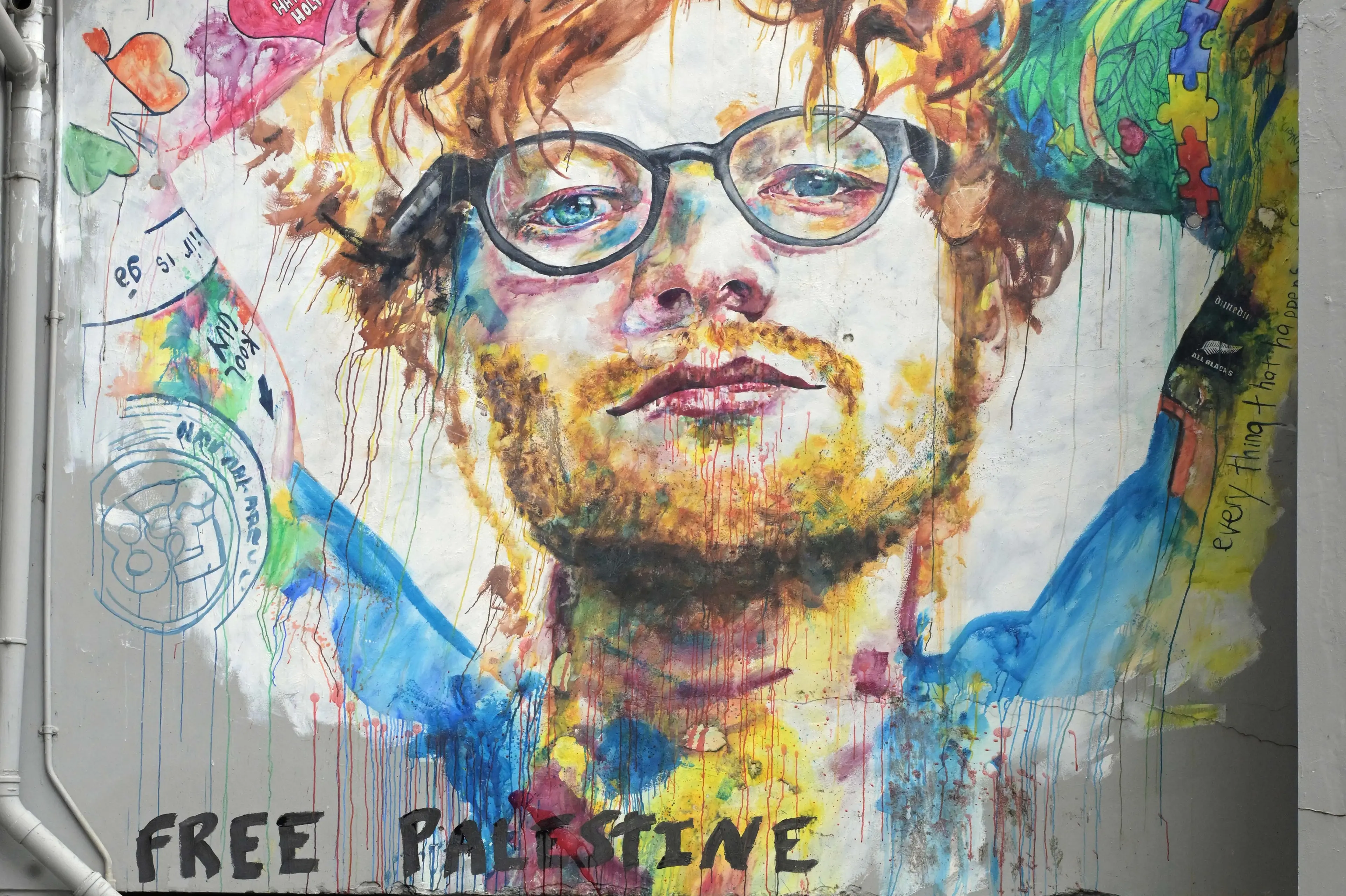 The Bath St mural of Ed Sheeran has been vandalised with a splatter of red paint and the words \"free Palestine\" written at the bottom. Photo: Gerard O\\'Brien