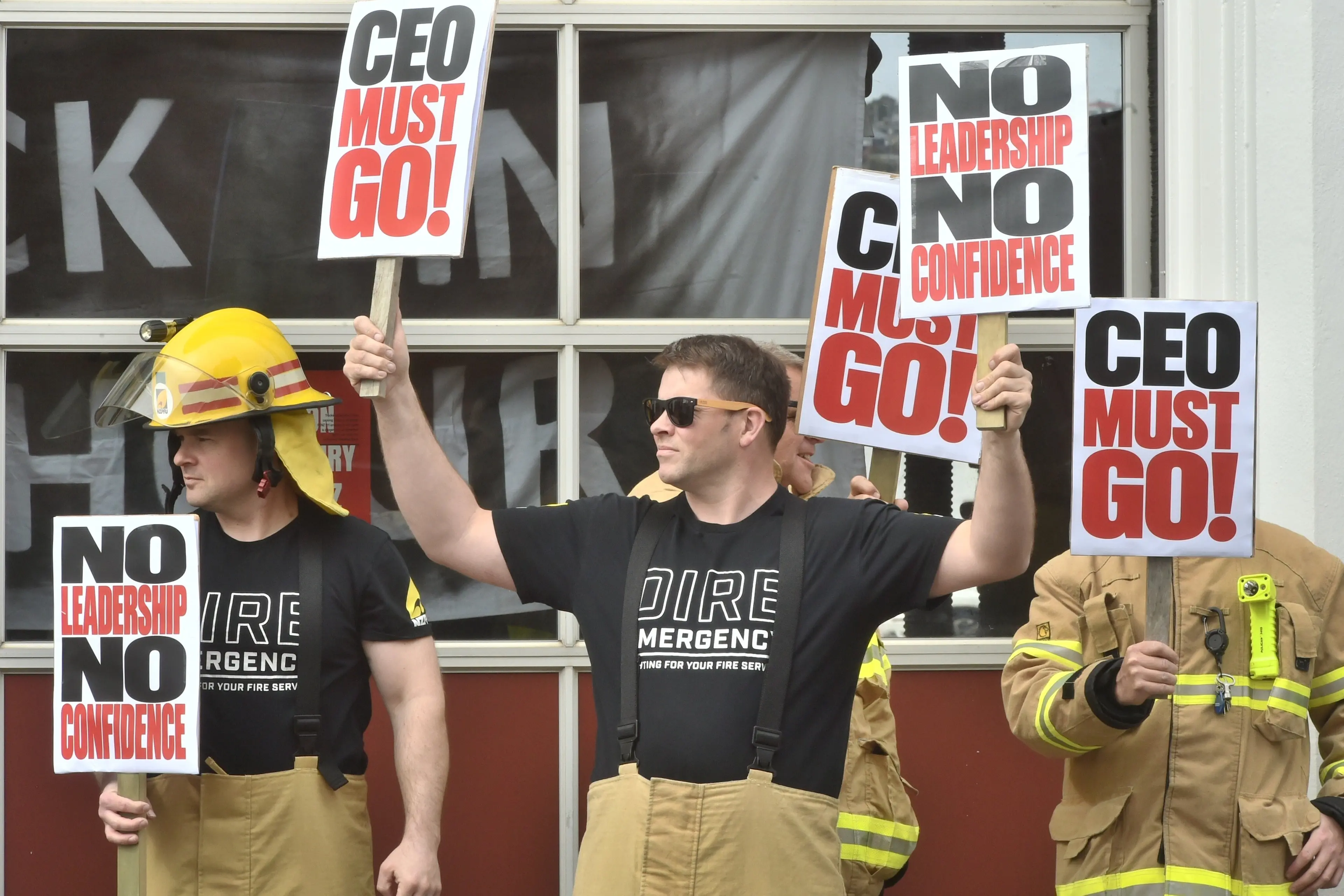 Striking firefighters (from left) senior firefighter Scott Haines and qualified firefighter Jamie Kerr hold signs of no confidence in Fire and Emergency New Zealand during an hour long strike on Friday. Photo: Gregor Richardson