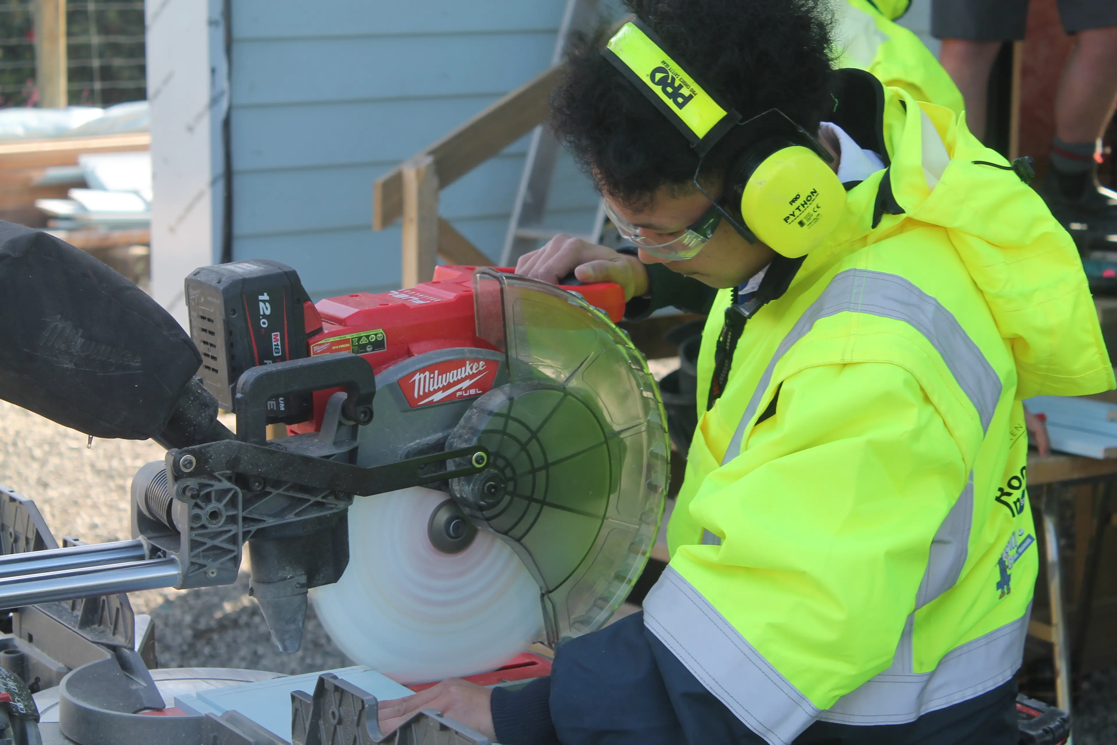 Clark Tolentino, 17, cuts a piece of plywood for the exterior of the house. Photo: Gerrit Doppenberg