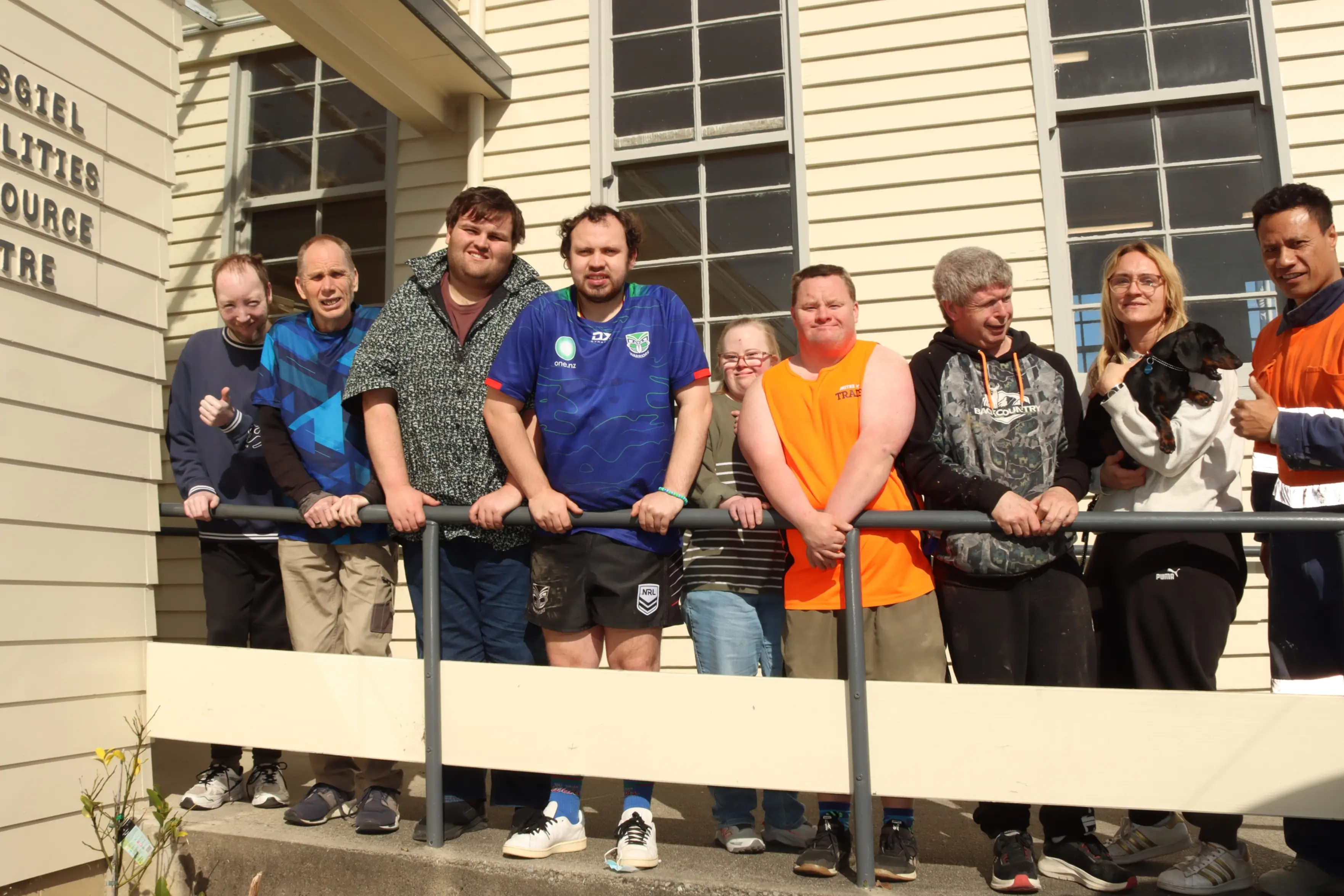 Users of the Mosgiel Abilities Resource Centre gather with vocational co-ordinators (right) Jamie-Lee Taucher (holding Mari the dog) and Iutana Feilo. Photo: Sam Henderson.