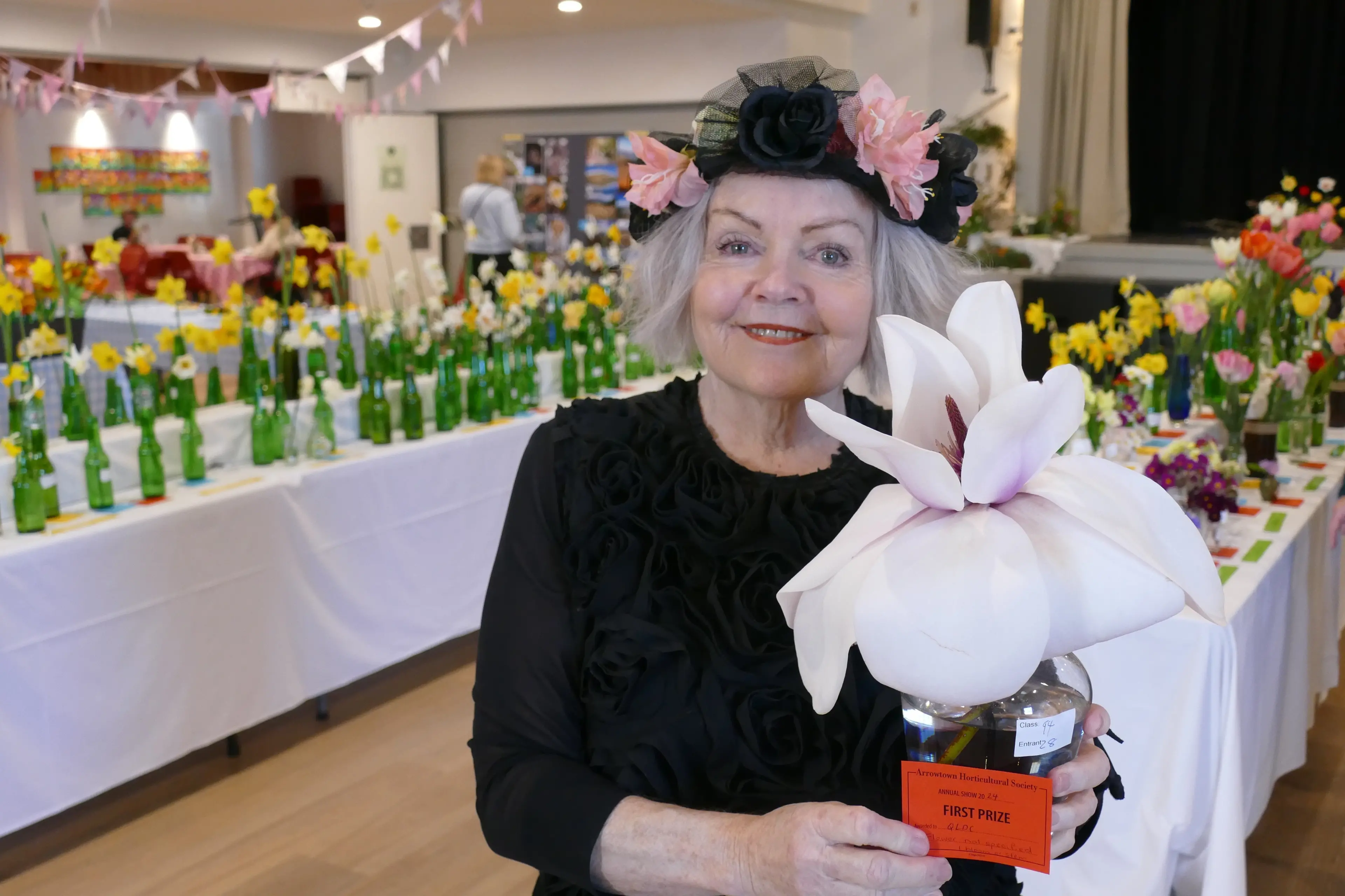 Flower power: Arrowtown Horticultural Society president Mary Phillips pictured with a prize-winning magnolia at an earlier Arrowtown Spring Flower Show - this year\\'s 103rd show, themed around the 1960s and \\'70s, opens to the public tomorrow afternoon. Photo: Archive