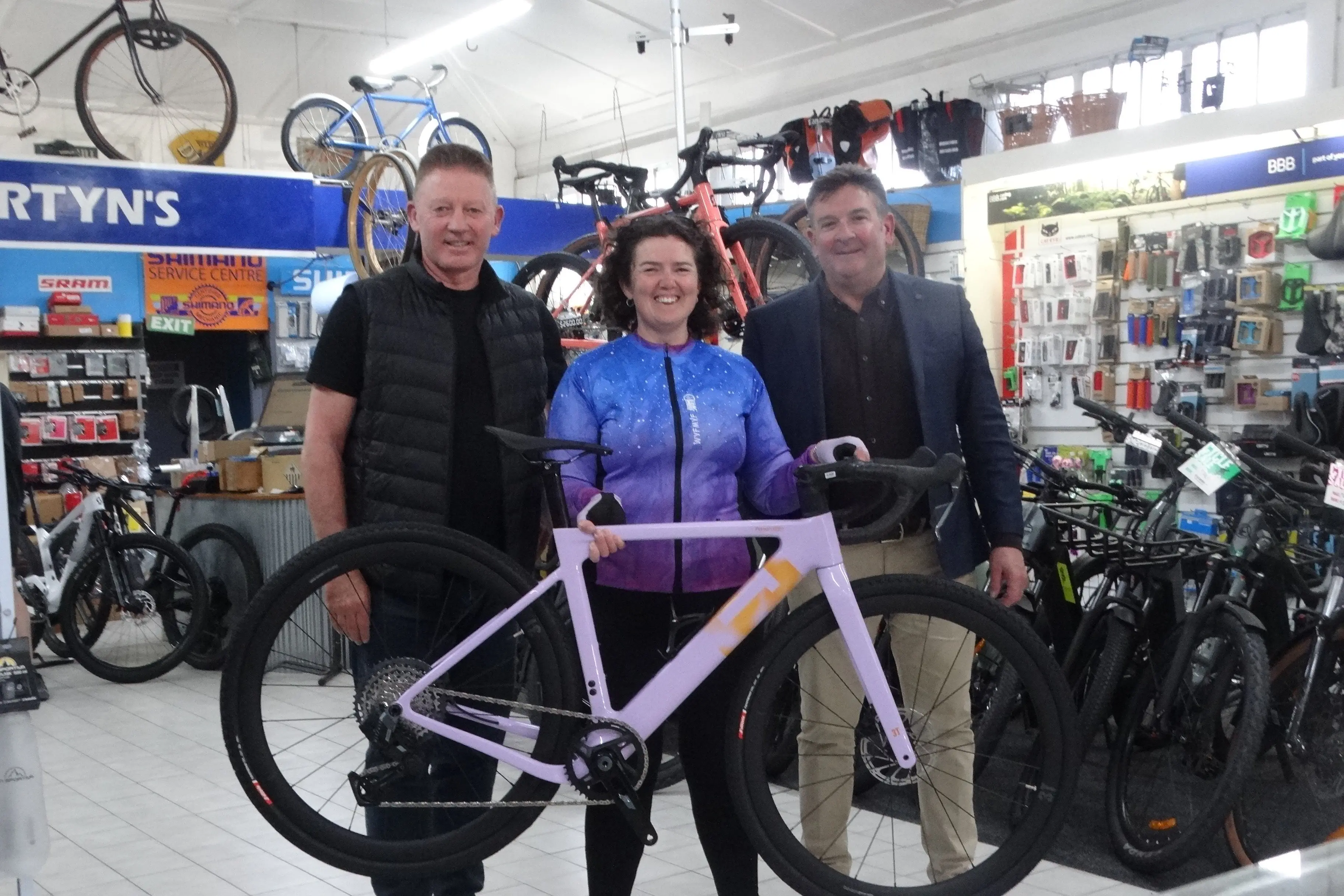 Amy Flottmann was presented with a gravel bike she won as a spot prize from entering the Gravel In Paradise series this year by Euro Cycling owner Darien Rush (left) and Cycling Otago race convener and gravel series director Grant Campbell (right) at Martyns Cycles in Oamaru recently. Photo: Nic Duff