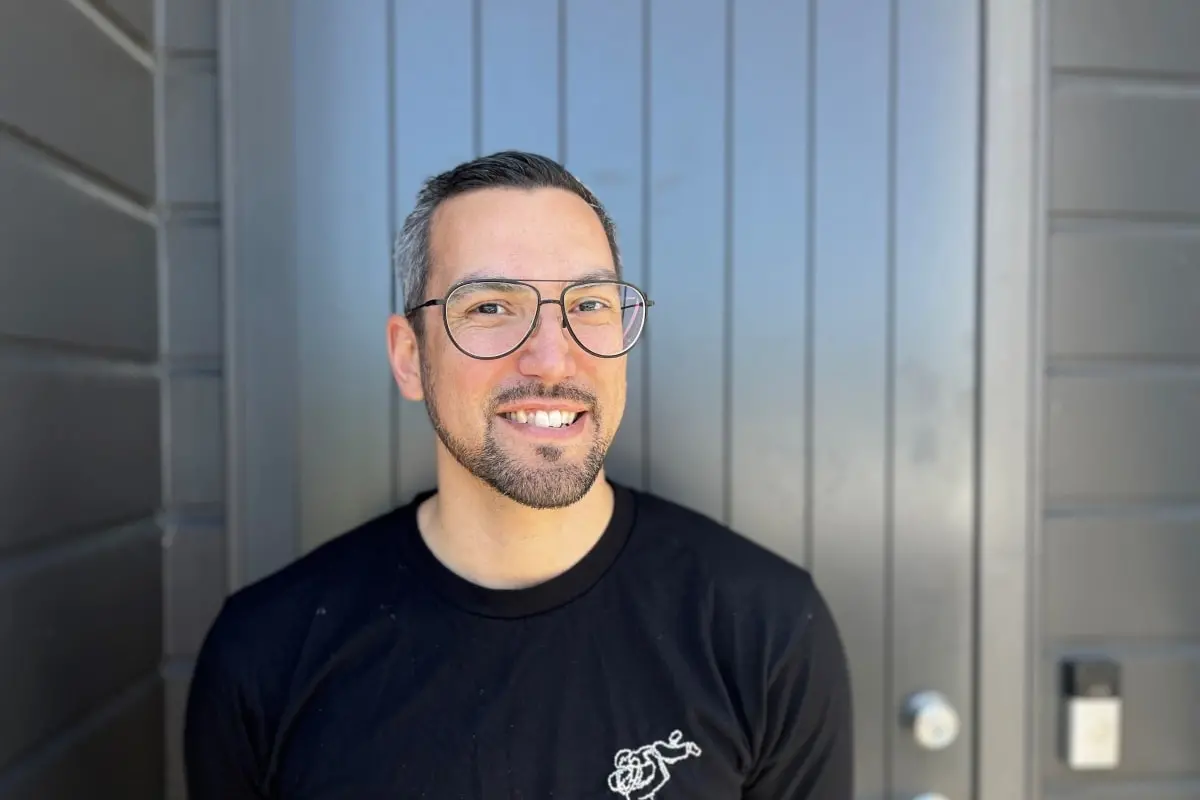 Jared Laidlaw says the aluminium front door behind him can get so hot to the touch in summer that it burns. Photo: RNZ