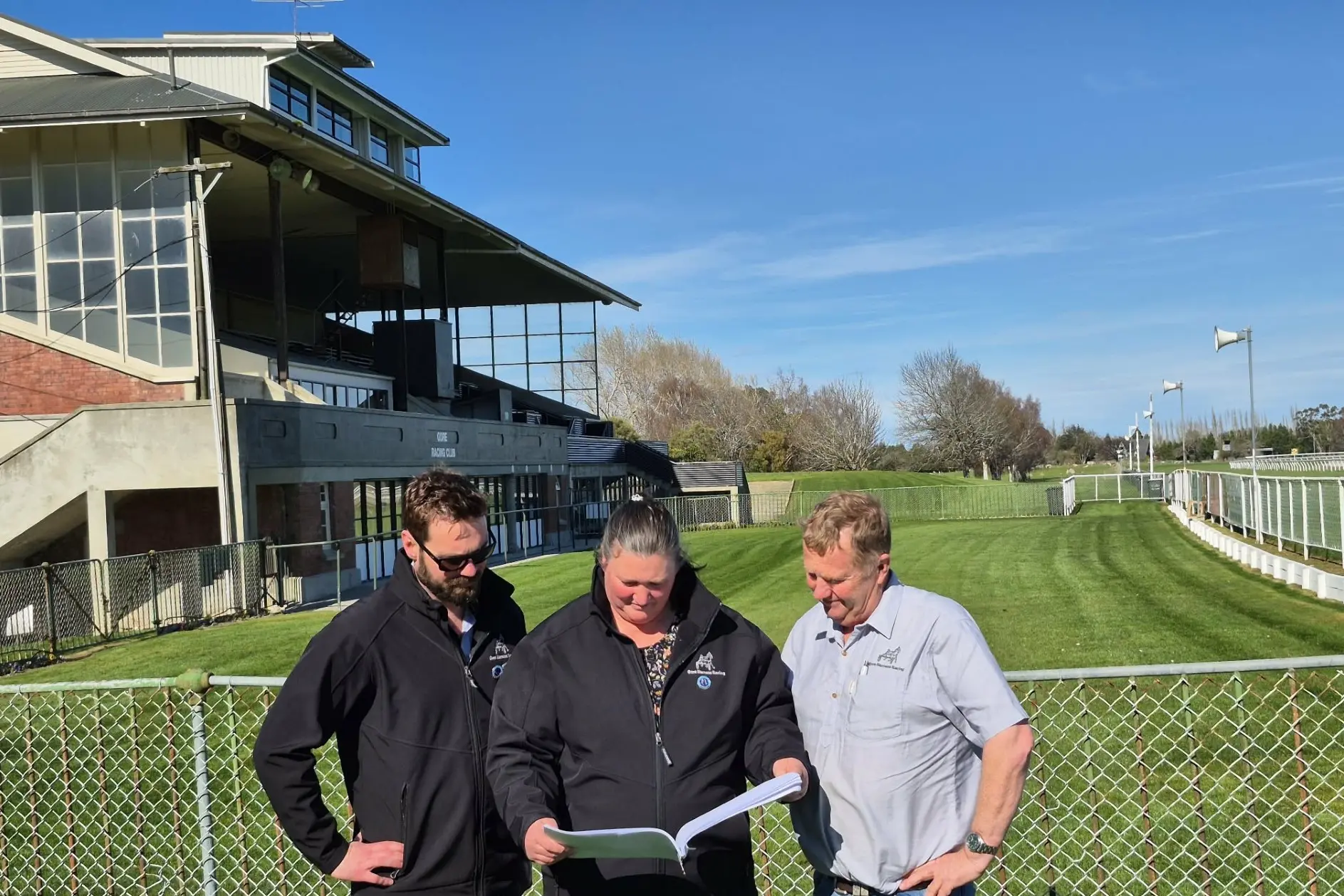 Gore Harness Racing Club junior vice-president Callum Dickson (left), president Lisa Barrie (middle), and life member and past president Ross Cleland read the report as the club prepares to submit an appeal on the decision to cease racing at the Gore Race Course, as the numbers show it\\'s continued popularity and success.  Photo: Supplied/Sonia Gerken