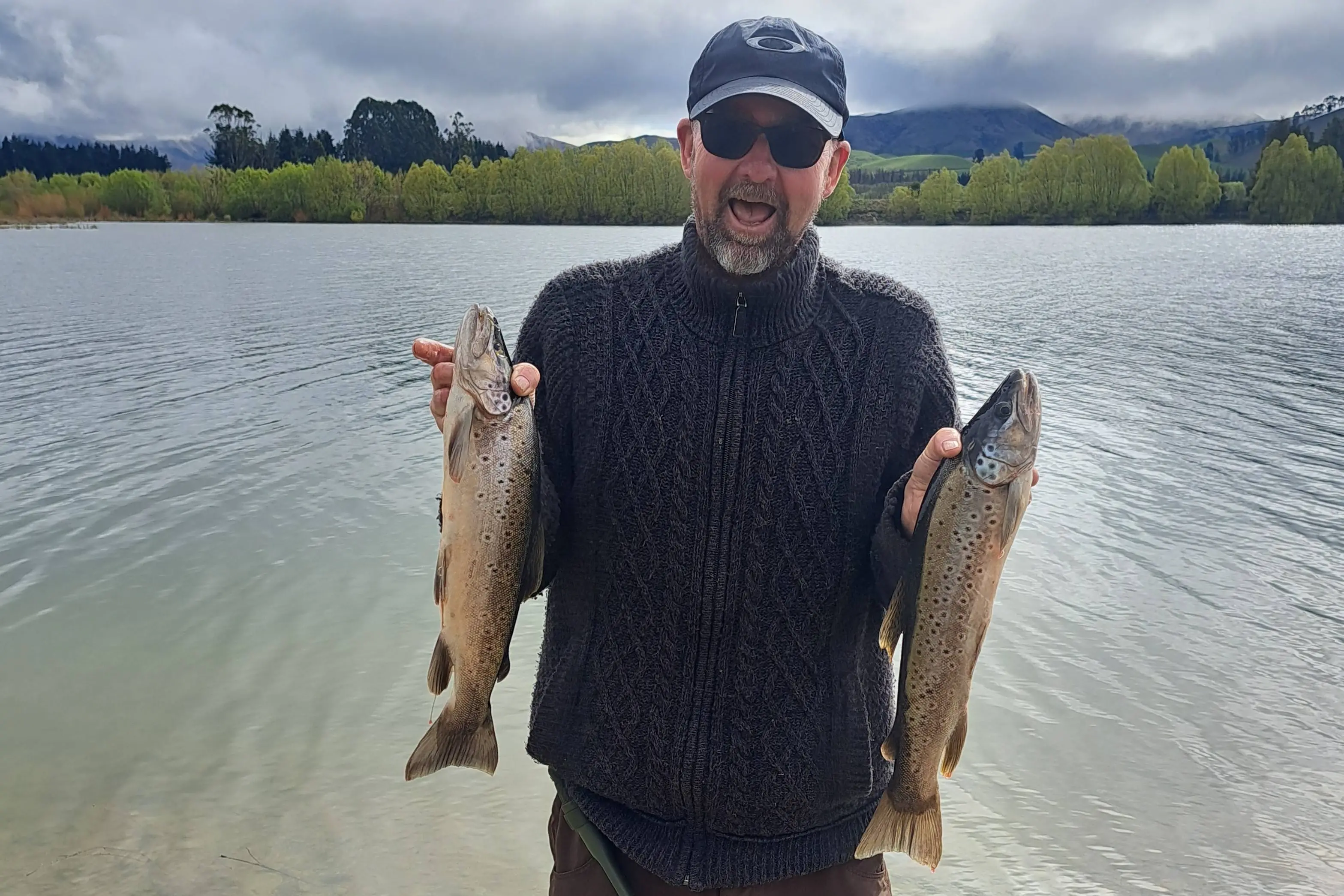 Reto Alig, of Temuka, at Lake Opuha with two brown trout caught on opening day 2025. Photo: Nikki Dellaway/Fish & Game