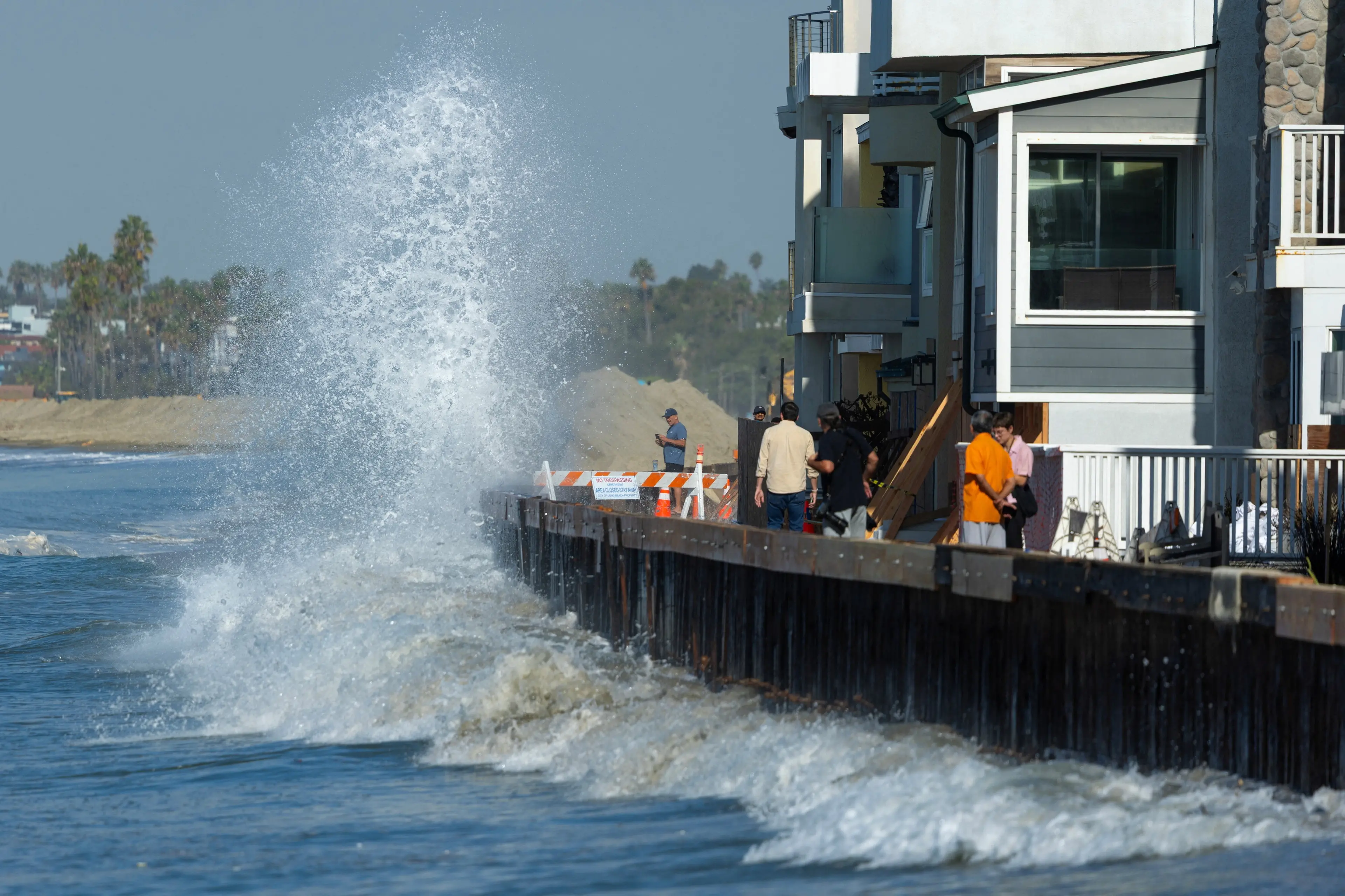 High tides and swells crash into a boardwalk quickly reinforced to protect houses in Long Beach, California. Photo: Reuters
