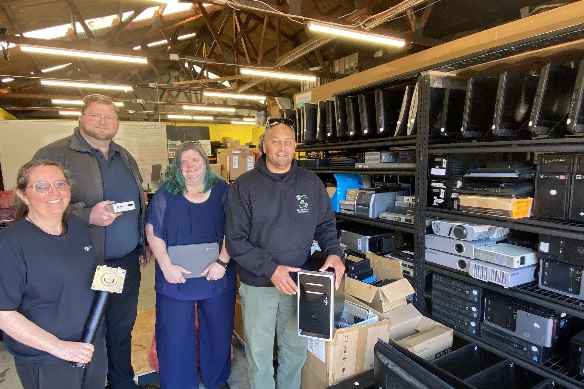 Com2Tech team members (from left) Mandy de Leeuw, board chairman Tim Gosling, and general manager Amy Souquet, are pictured with Fern Collective Ltd youth support worker Nathan Rotch at the Com2Tech e-waste centre in Harrow St, Dunedin North. Photo: Brenda Harwood