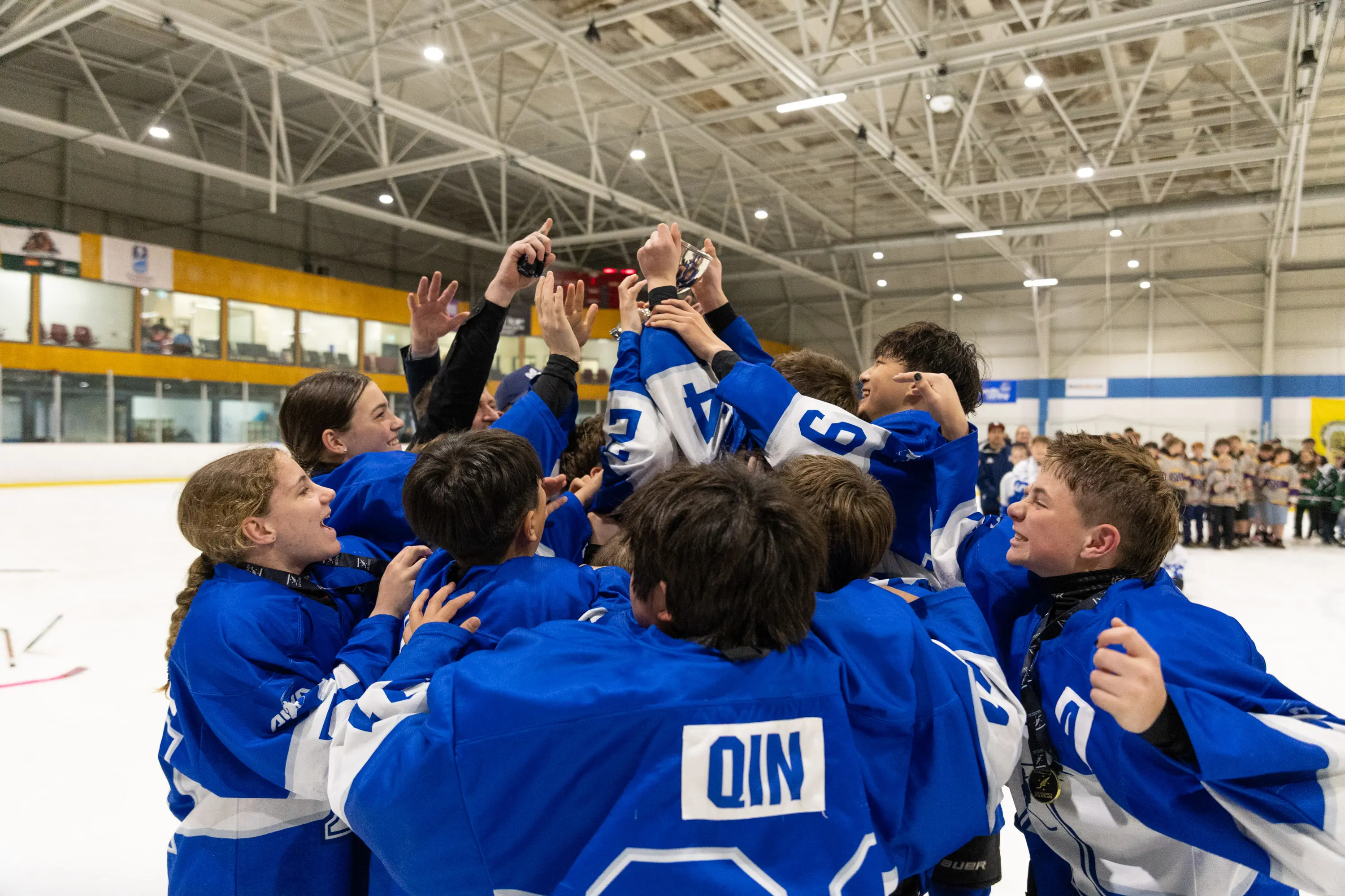 Auckland Blue ice hockey players celebrate their New Zealand under-14 title at the Dunedin Ice Stadium. Photo: Keaphotos