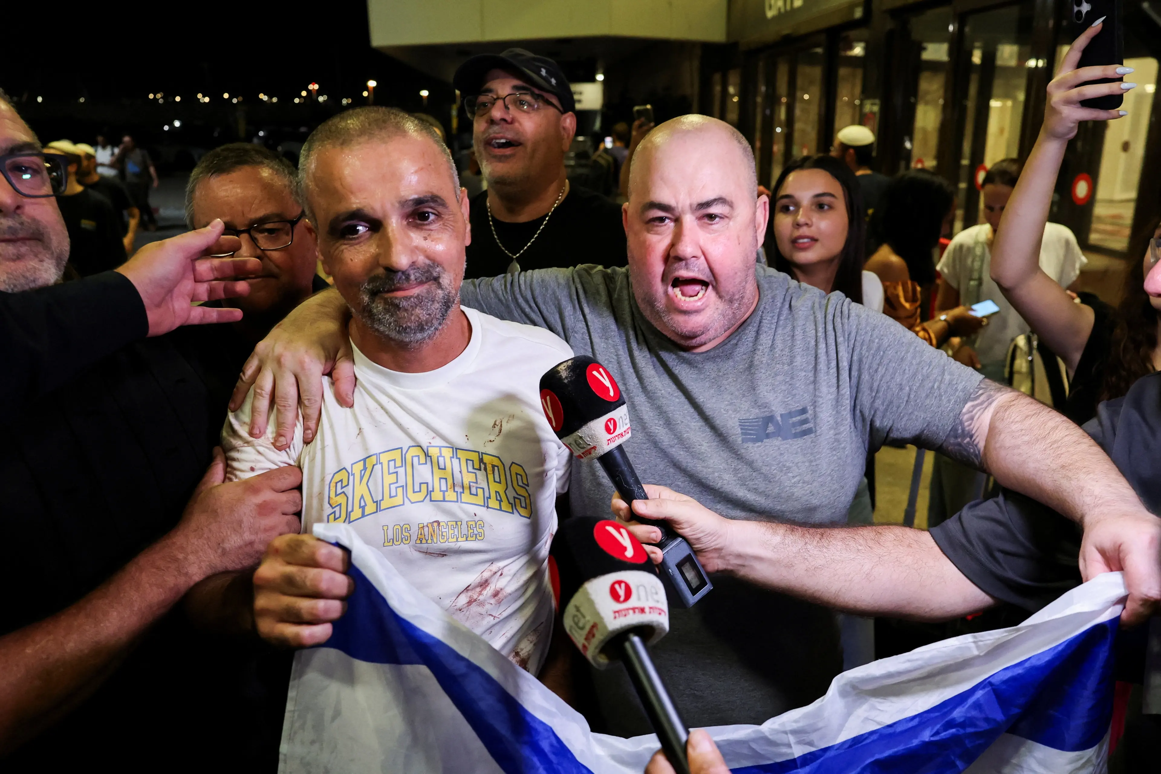 Yaniv Hayun, one of the men who helped incapacitate the attacker on the aircraft, holds an Israeli flag after arriving at Ben Gurion International Airport near Tel Aviv. Photo: Reuters