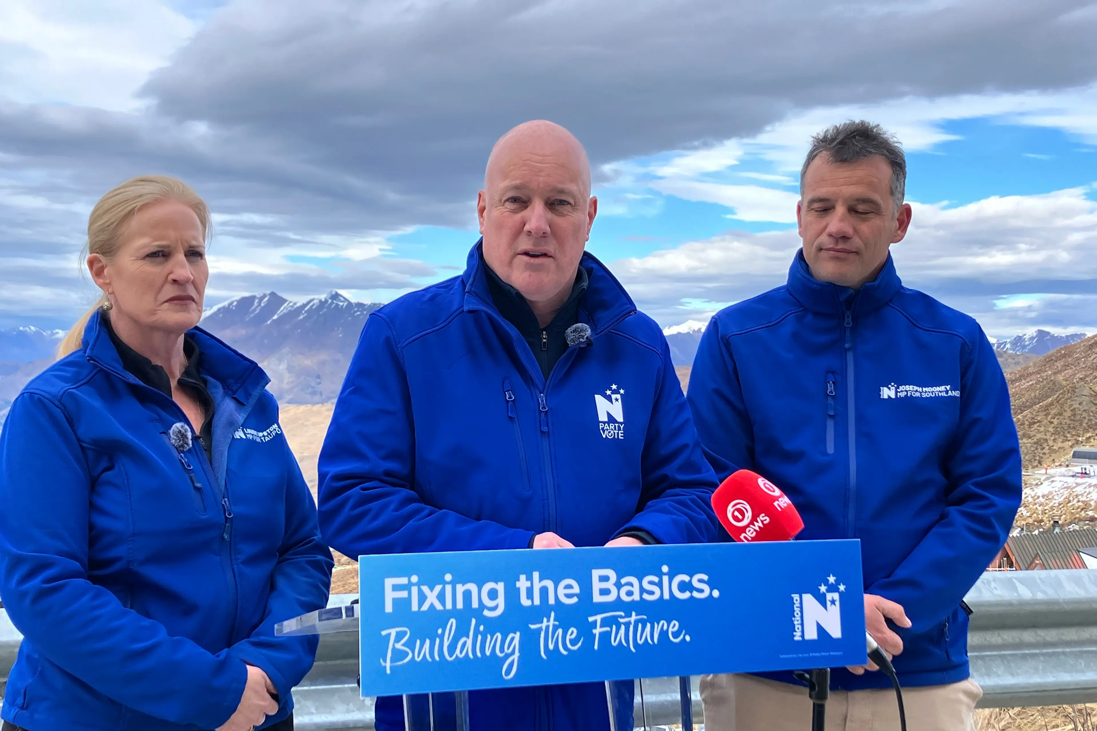Prime Minister Christopher Luxon (C) speaks in Queenstown on Thursday flanked by tourism spokesperson Louise Upston (L) and Southland MP Joseph Mooney. Photo: Tracey Roxburgh