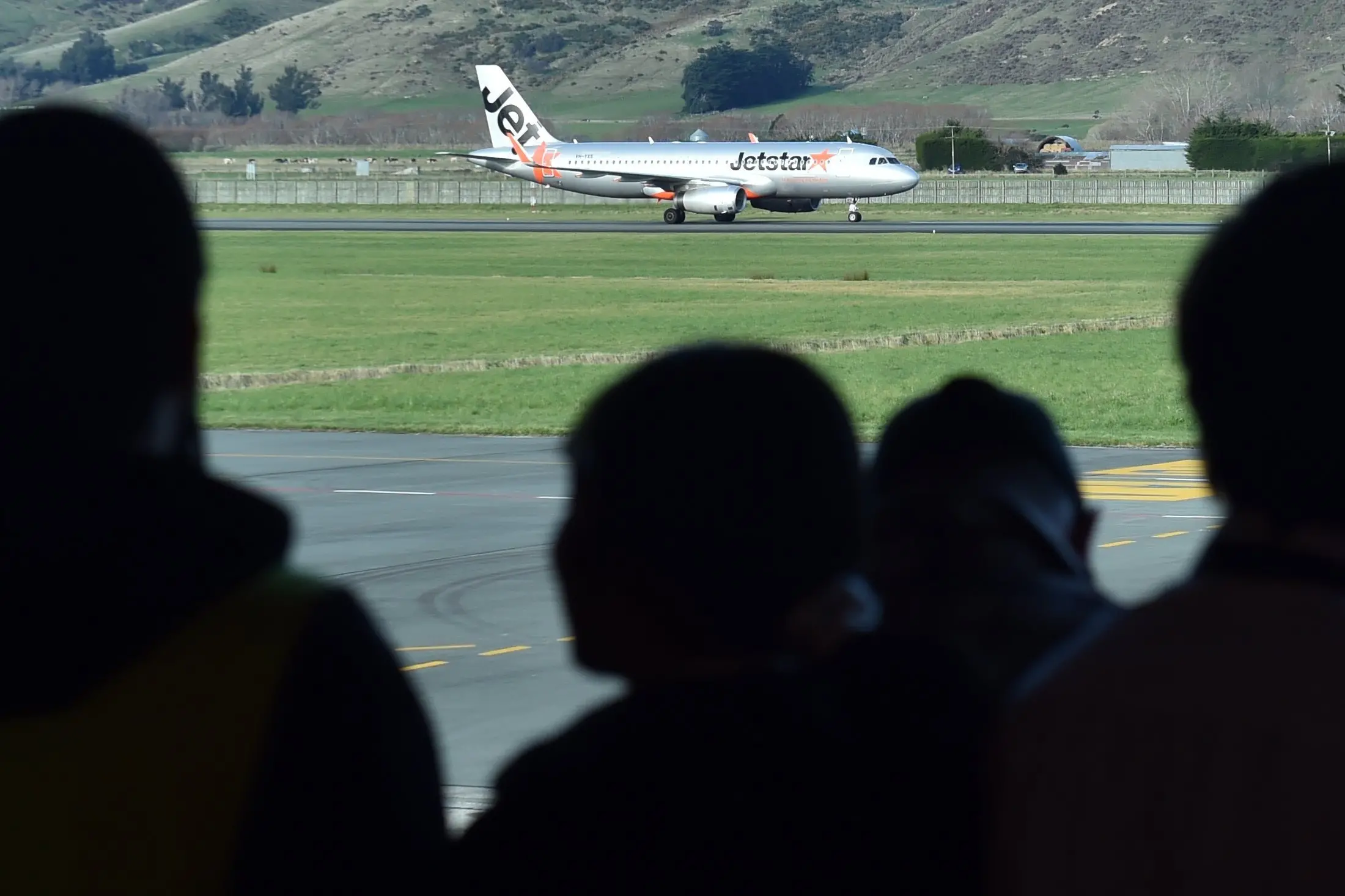 A crowd watches the first Jetstar flight from the Gold Coast land at Dunedin Airport, in June 2025. Photo: Peter McIntosh