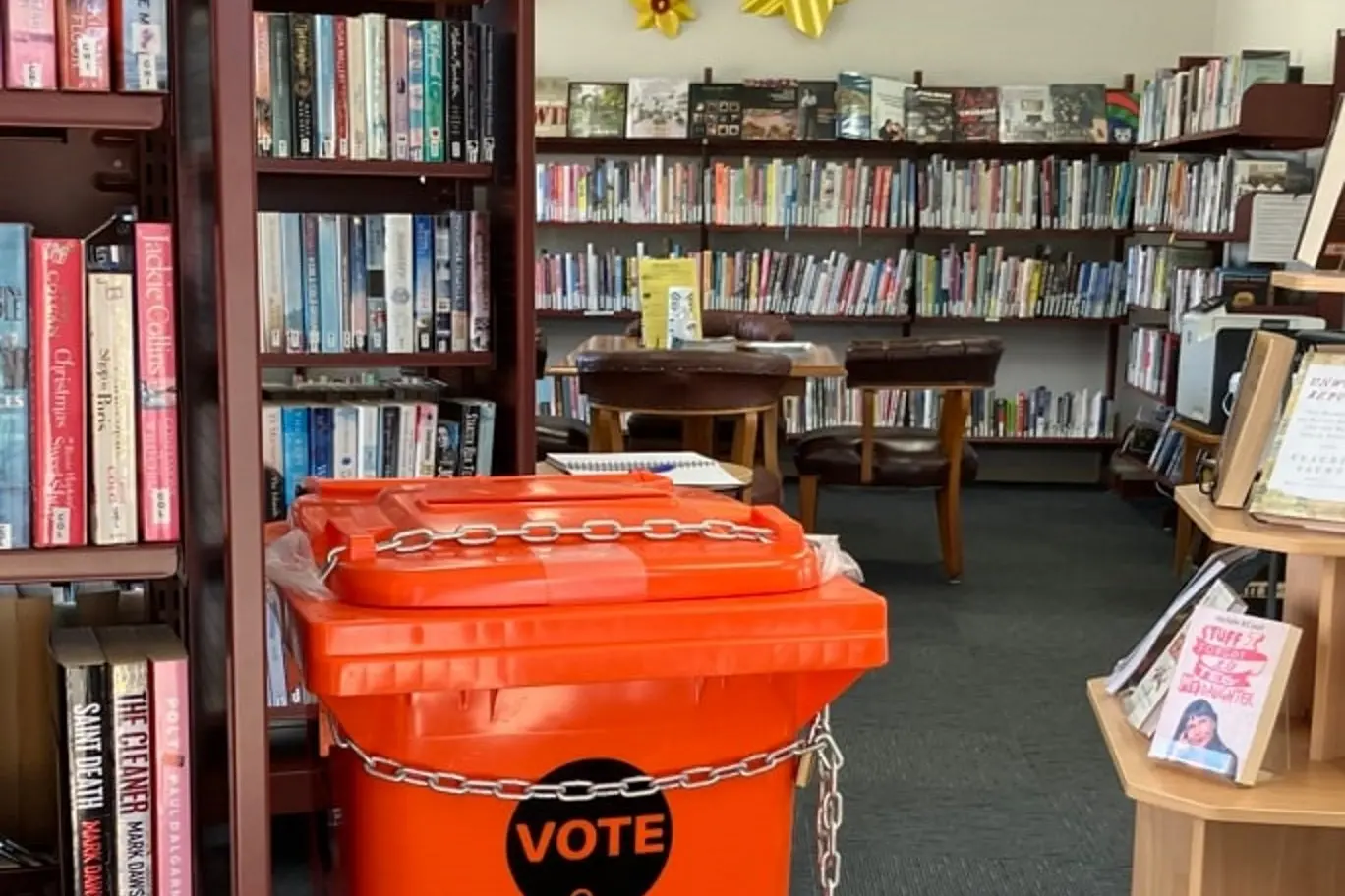 Voting . . . A orange bins at the Amberley Library from a past Hurunui District Council election. Could local government elections return to in-person voting. Photo: Hurunui District Council
