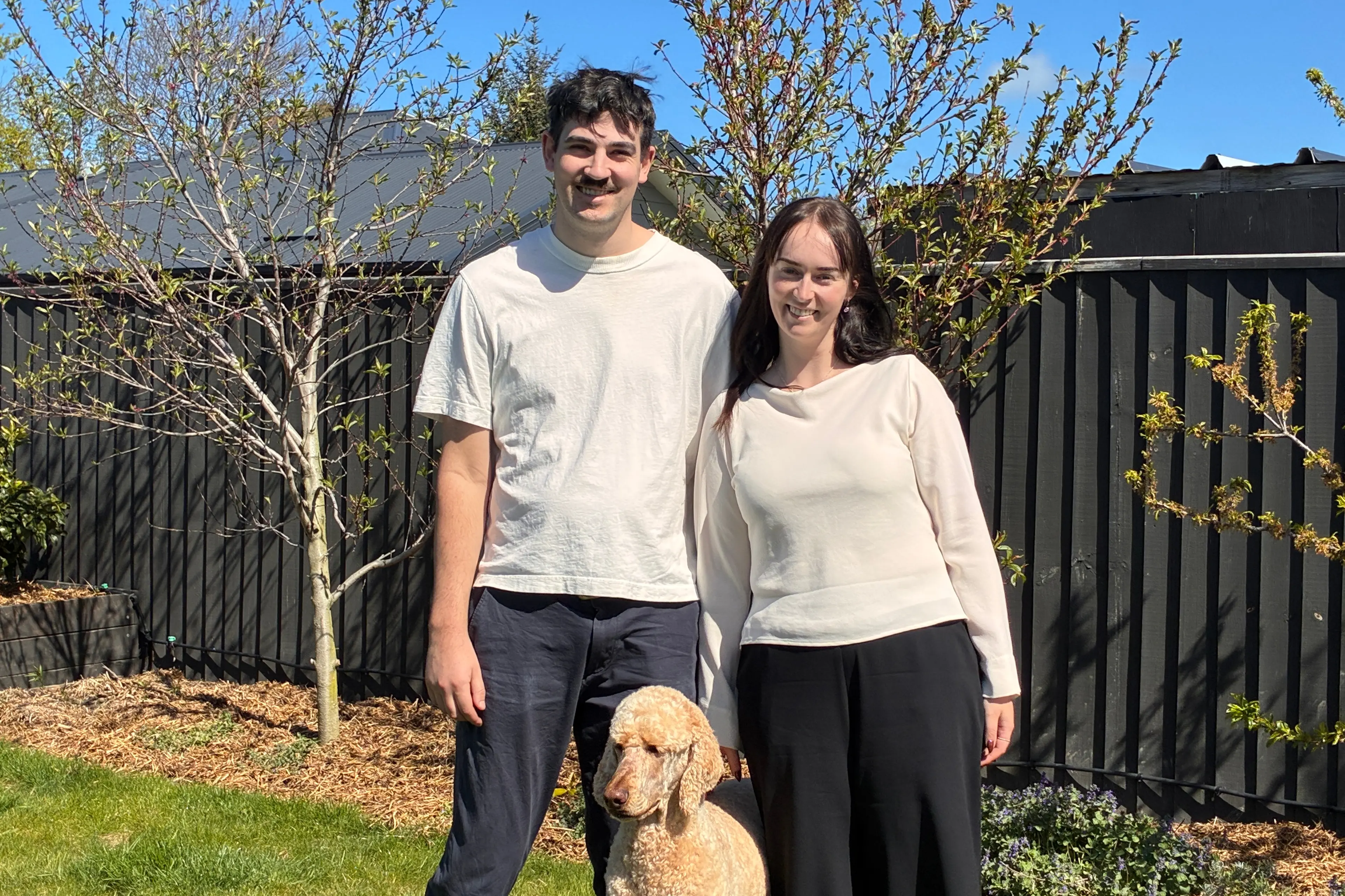 Thomas Cockburn and Eilish Robinson-Kelly at their Rolleston home with poodle Luca. Cockburn is now a year on from his life-changing Motor Neurone Disease diagnosis. PHOTO: SAM COUGHLAN
