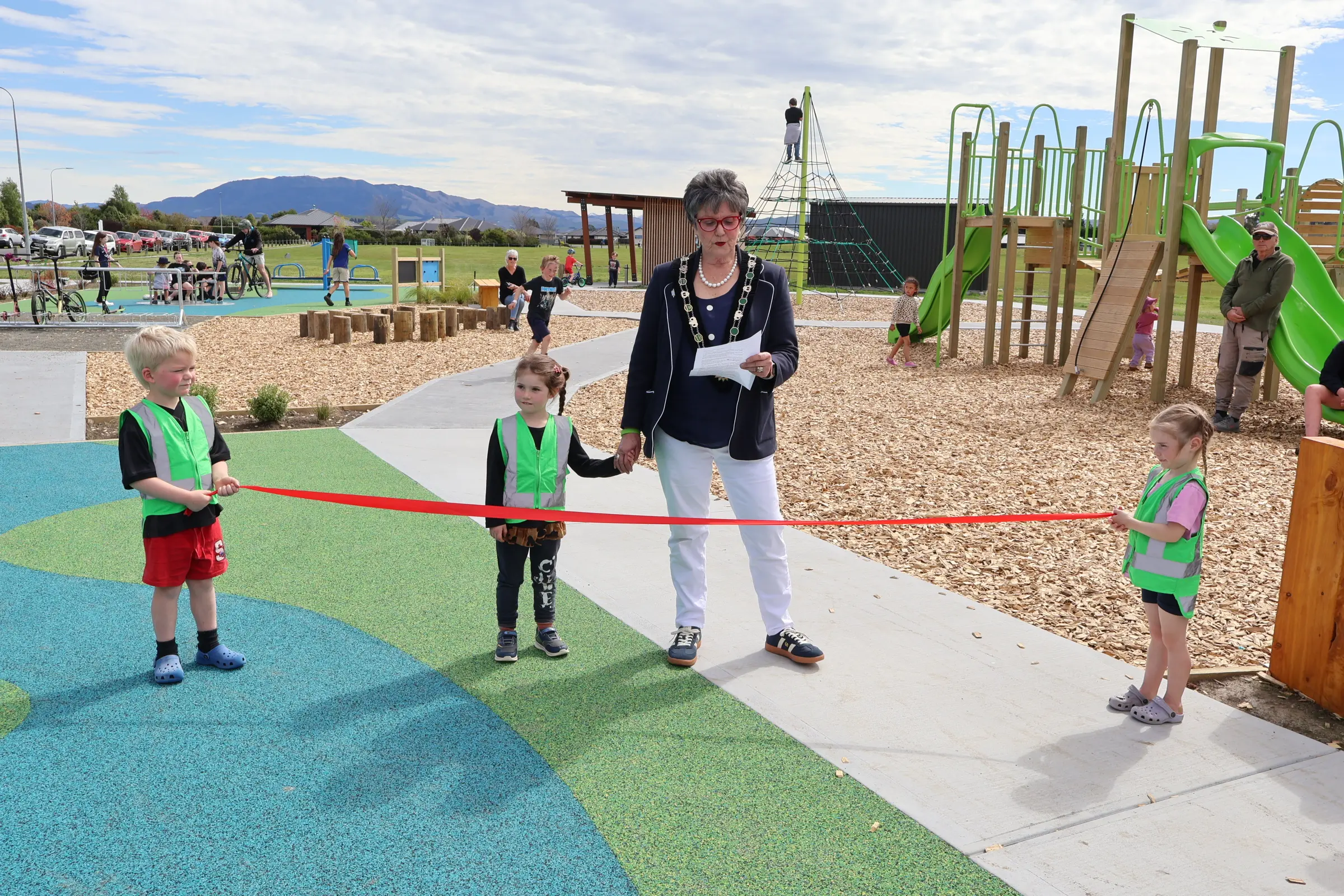 Playtime . . . Hurunui Mayor Marie Black officially opens the Amberley Village Green playground with help from Axel Rattray (left), Maisie Ballan and Skyla Schunacher of Little Oaks Preschool. Photo: Supplied