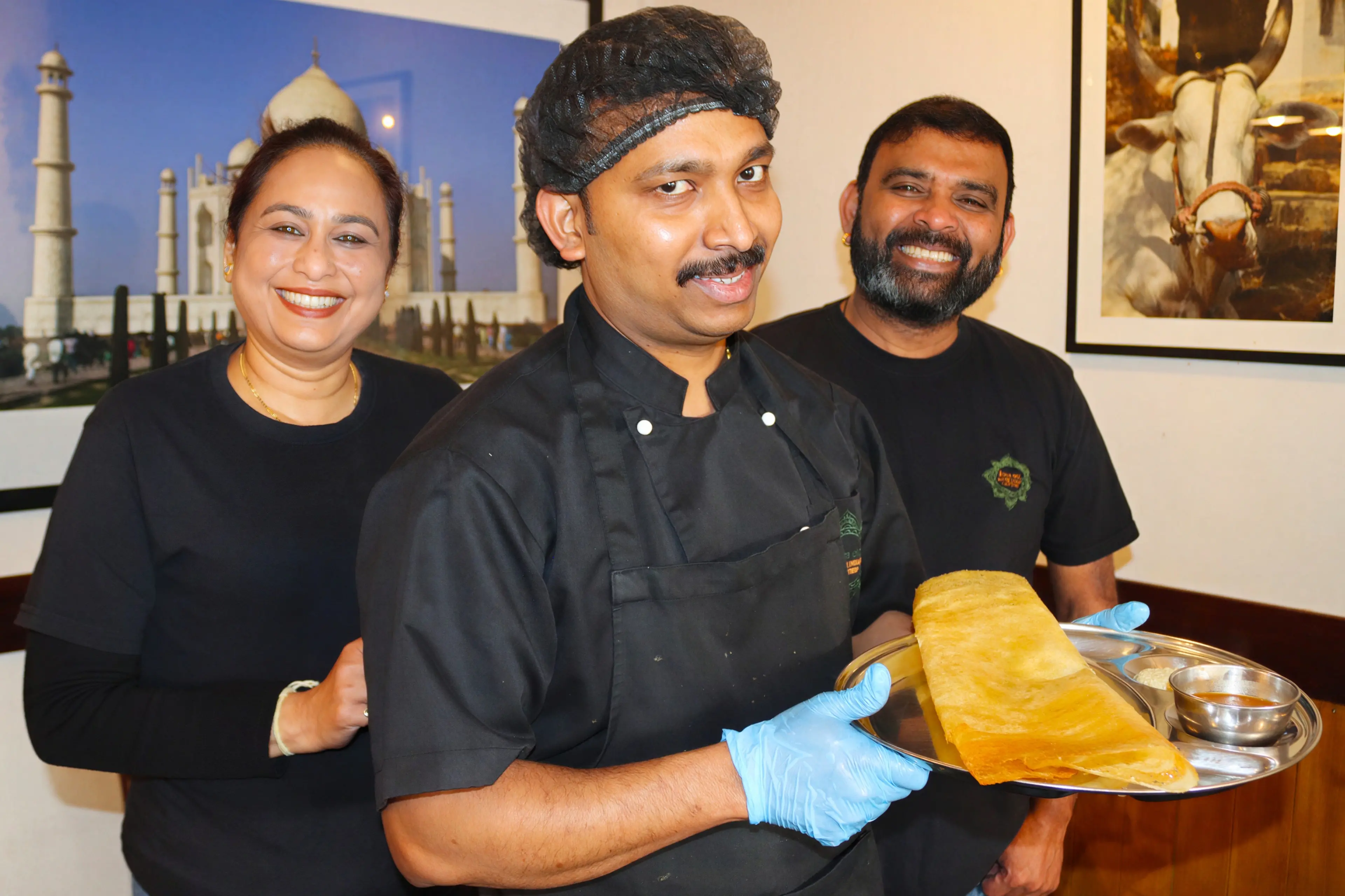 Dosa ETC chef Sudhakar Ganesan (centre) shows a dish of dosa, a crepe filled with potato, onion and spices with owners Vinutha Subramanya (left) and Srikanth Subbarao. Photo: Sam Henderson