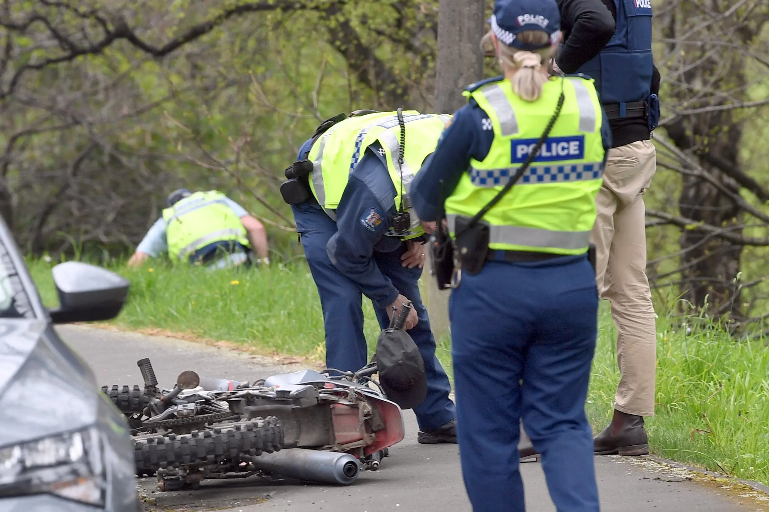 Police inspect a dumpted motorcycle in South Rd. Photo: Stephen Jaquiery
