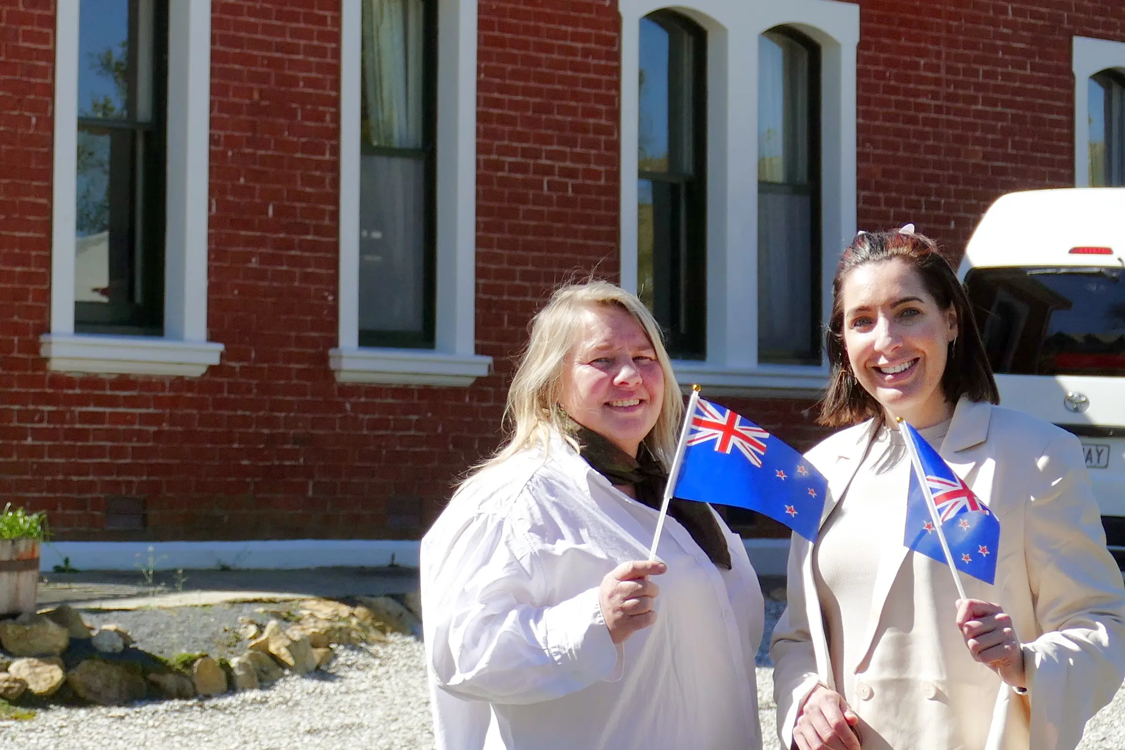 National Anthem 150th Jubilee committee members Liz Ritchie, left, and Arna Smith, fly the flag outside anthem composer JJ Woods\\' Lawrence home last week. Photo: Richard Davison