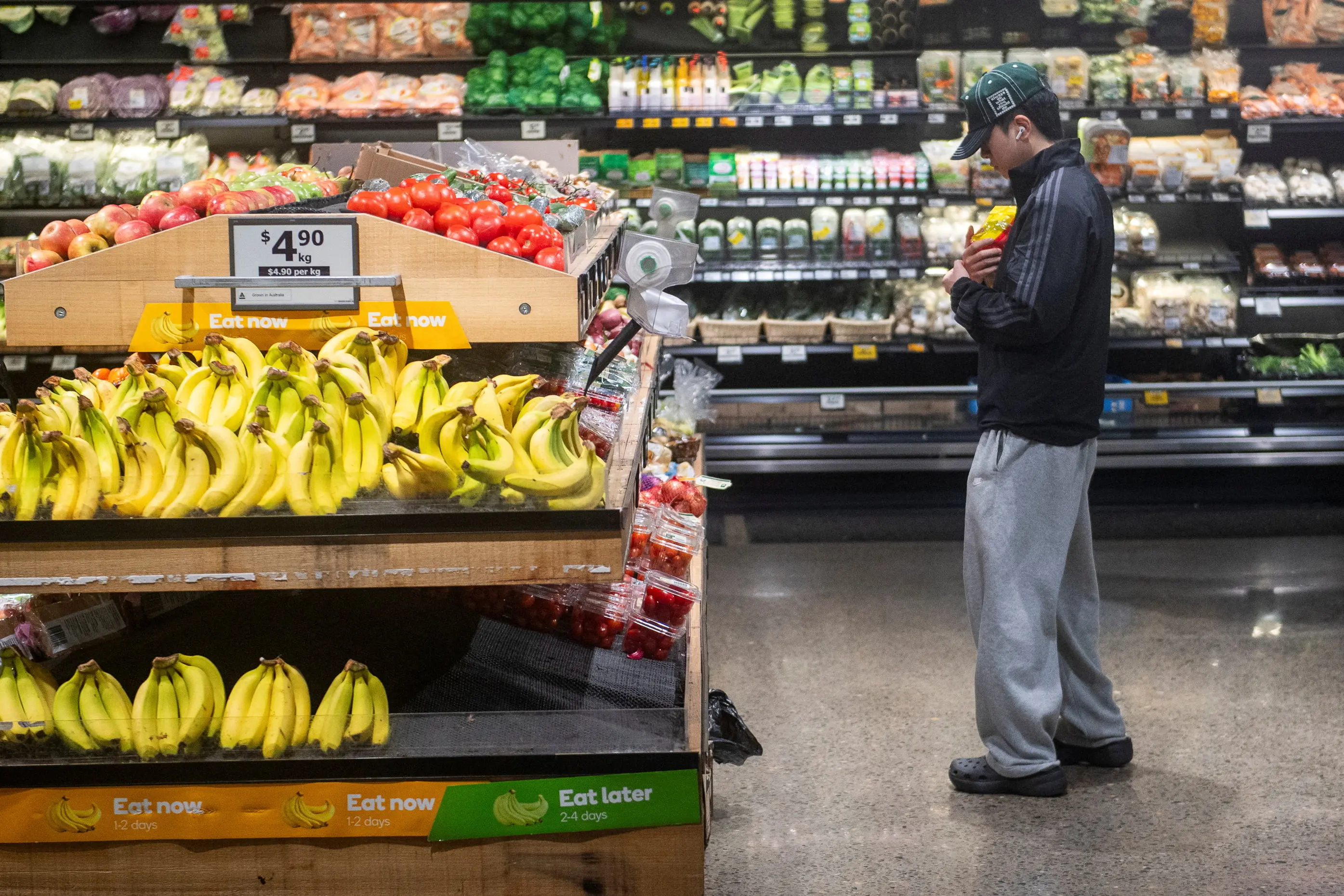 A shopper checks out produce prices at an Australian supermarket. Photo: Reuters