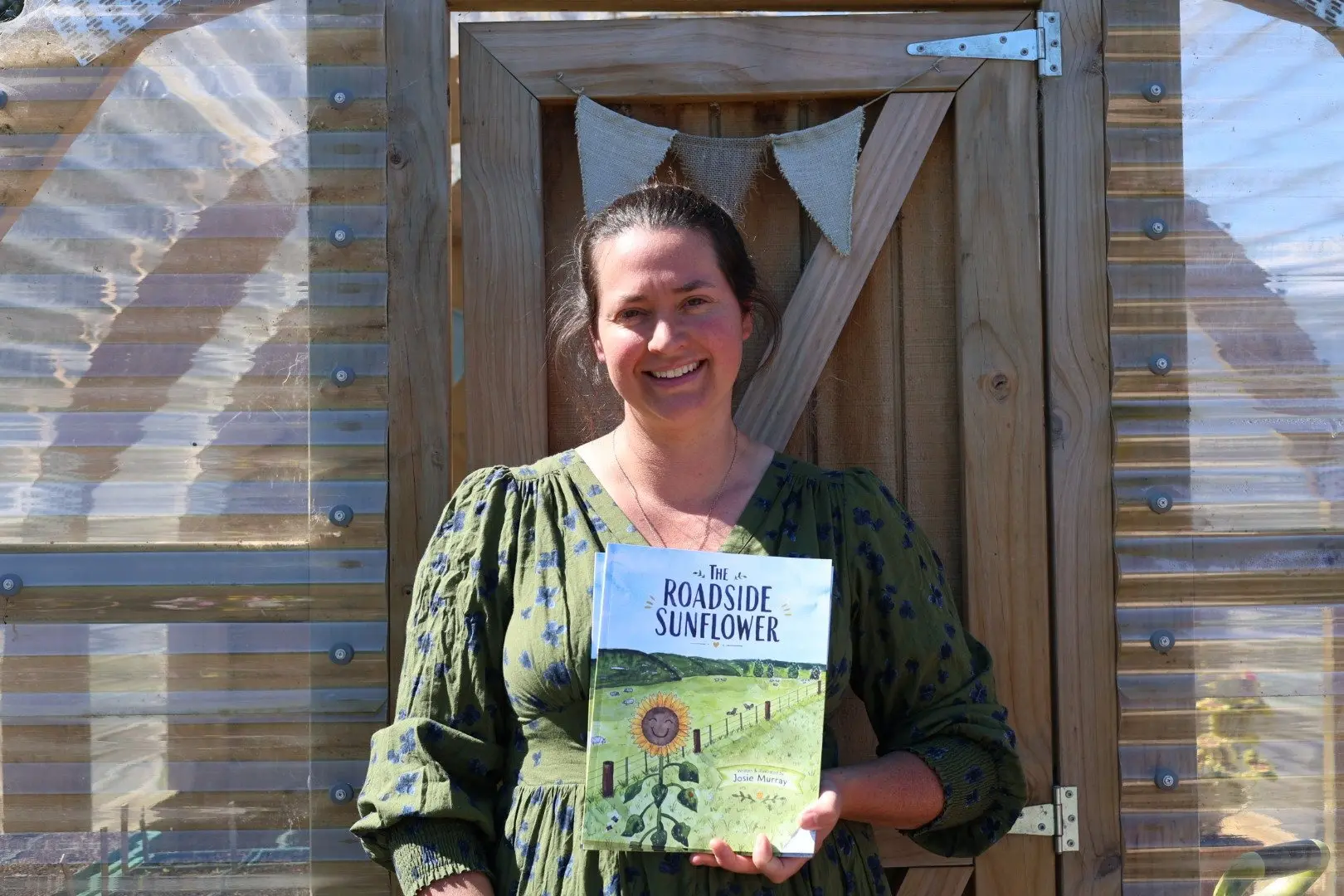 Josie Murray holds copies of her first book The Roadside Sunflower on her farm in Hakataramea Valley. Photo: Supplied