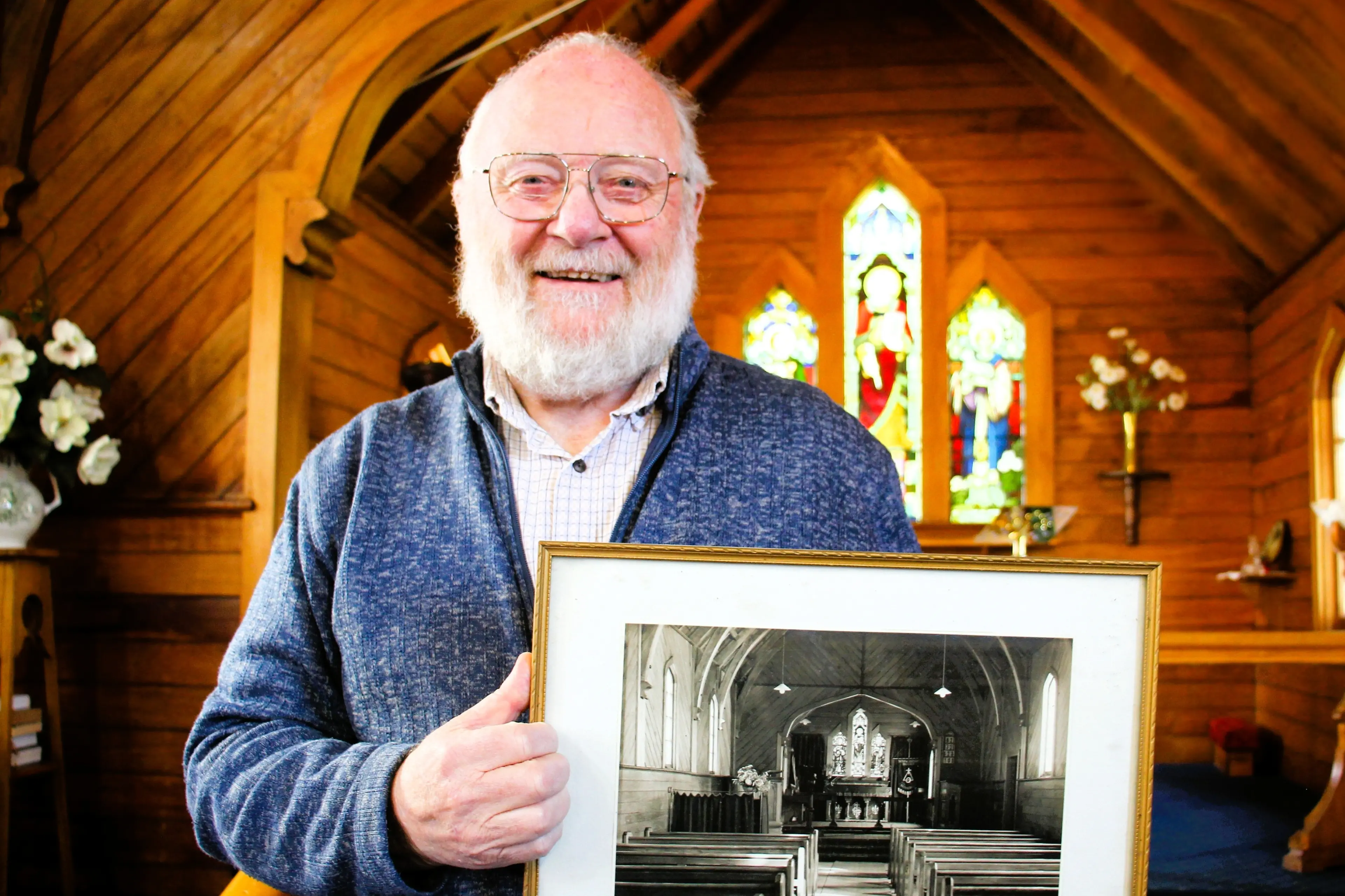 The Reverend Derek Harding holds a photo of the interior of St Luke\\u2019s in 1949. Photo: Paula Hulburt.