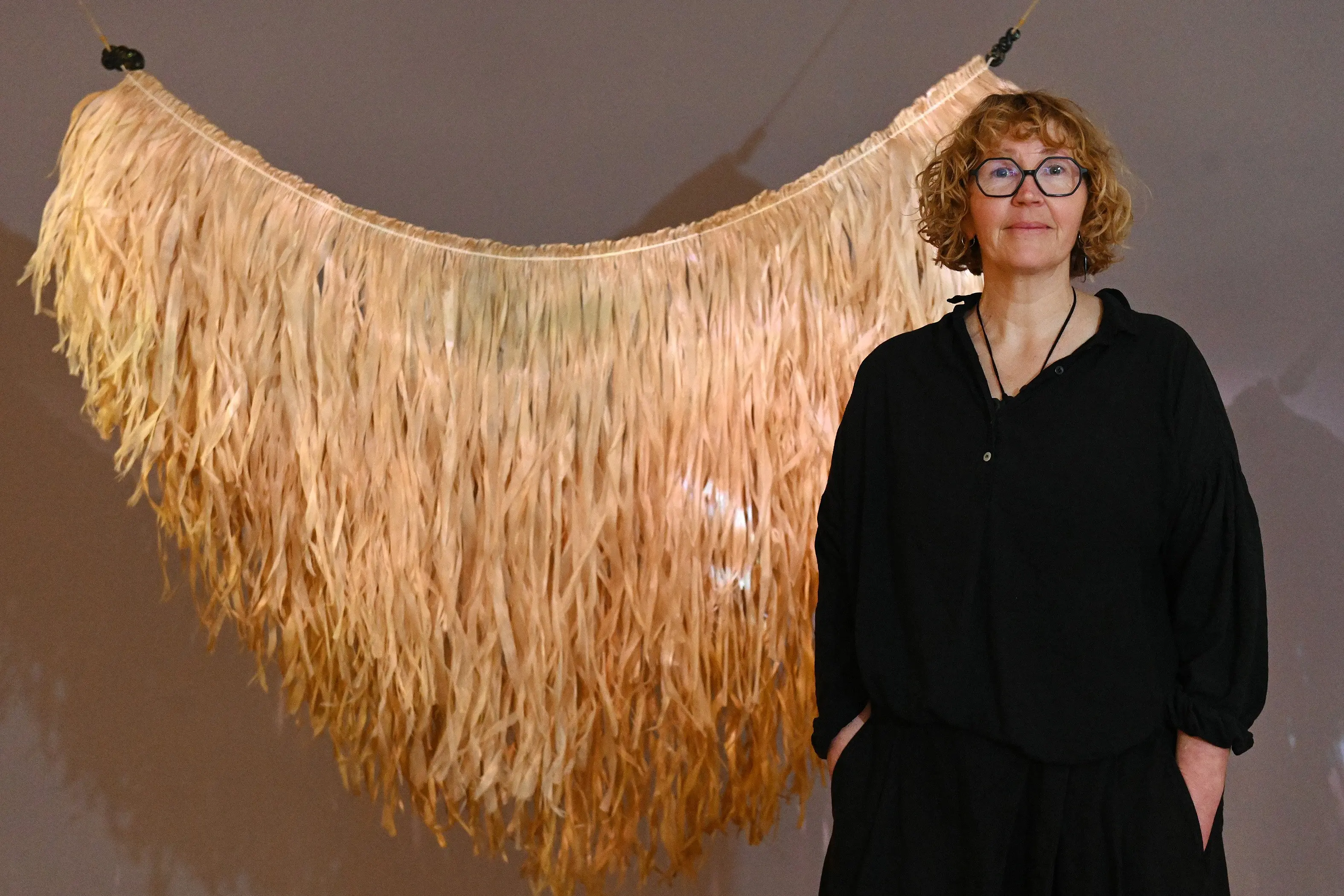 Textile artist Georgina May Young with <i>K\\u0101rohirohi \\u2013 meet you at the awa</i>, 2026, houhere, muka, pounamu, video, sound. Photo: Linda Robertson