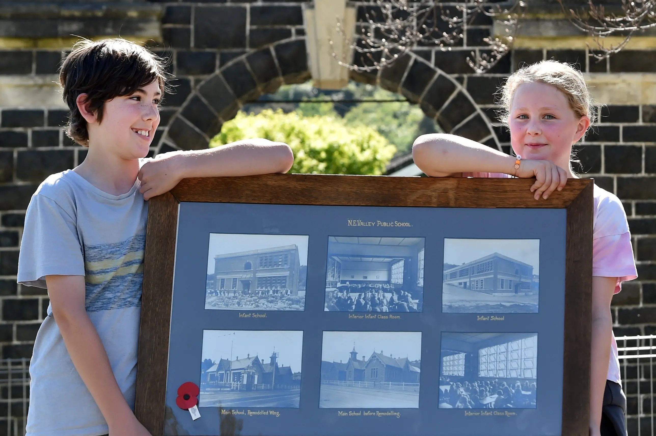 North East Valley Normal School pupils (from left) Atlas Guyton, 10, and Lilly Howie, 10, hold photos showing what their school looked like before buildings were all replaced as the school prepares to celebrate their 175th birthday on Friday. Photo: Peter McIntosh