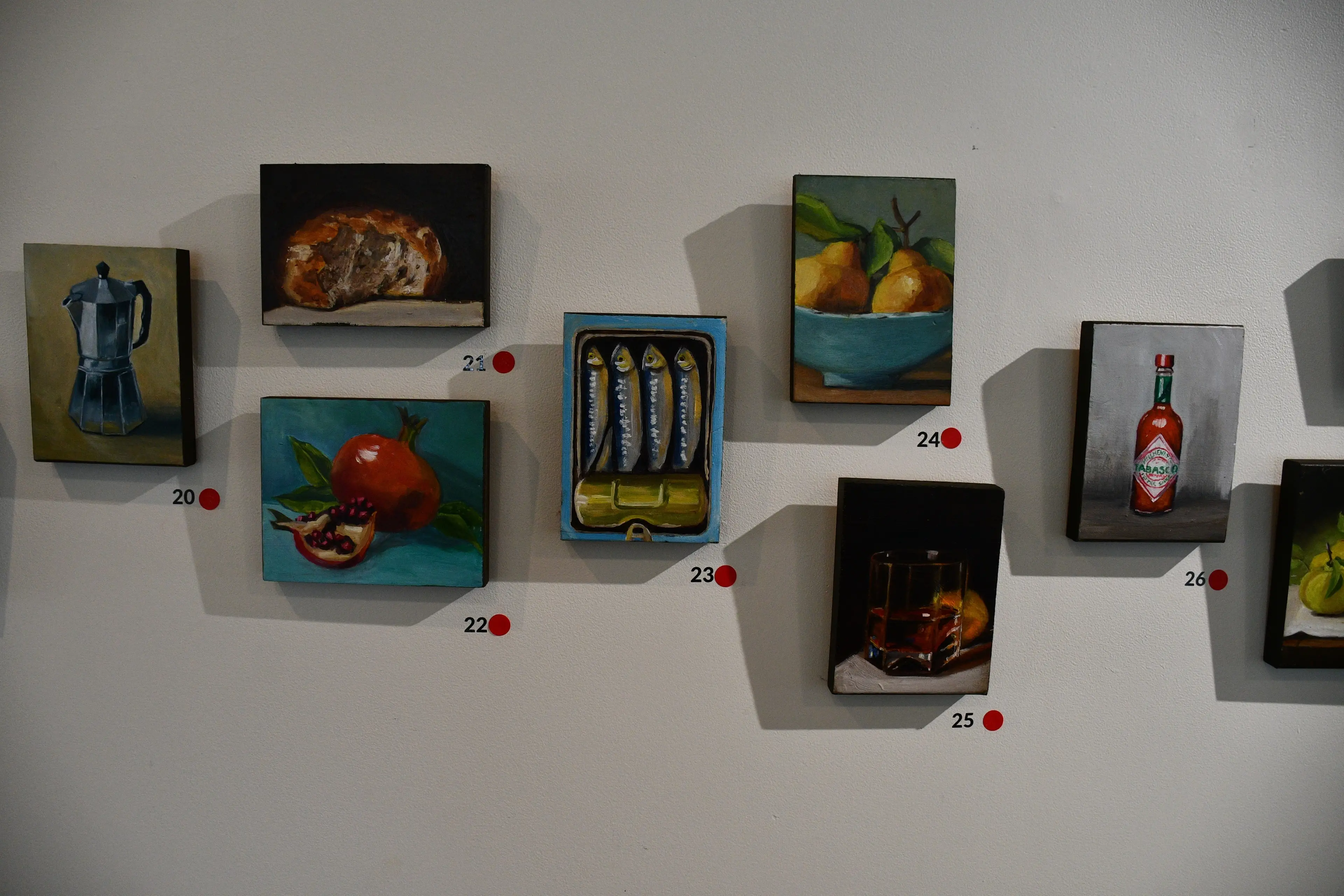 Many of Jude Taylor\\'s small paintings on recycled wood in her first major exhibition in Mandeville feature scenes of the kitchen, a nod to the chef\\'s passion for food. Photo: Gemma Sinclair