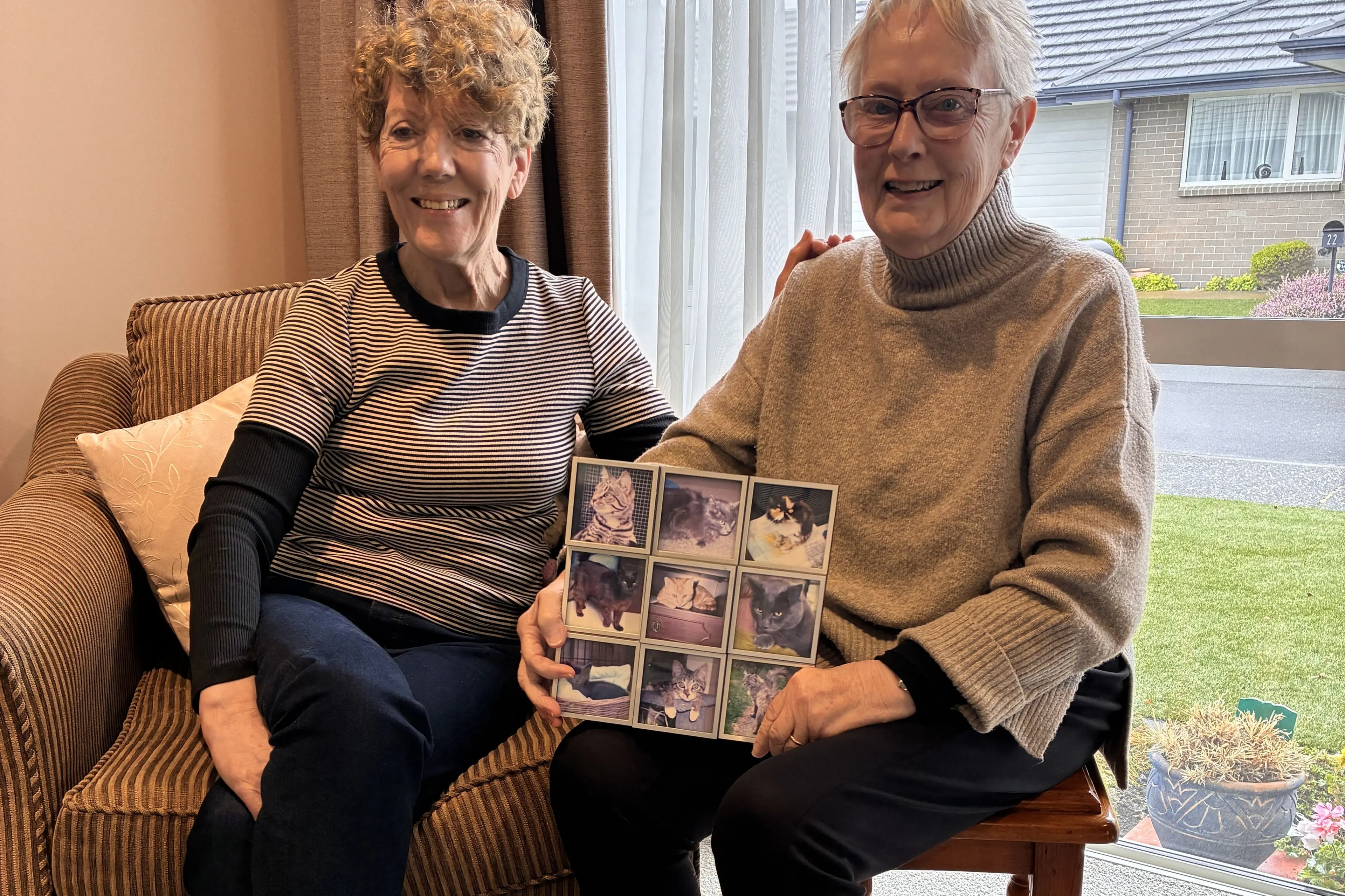 Caring for cats . . . Christine Walker and Betty Jones with photos of some of the first cts and kittens rescued. Photo: Supplied