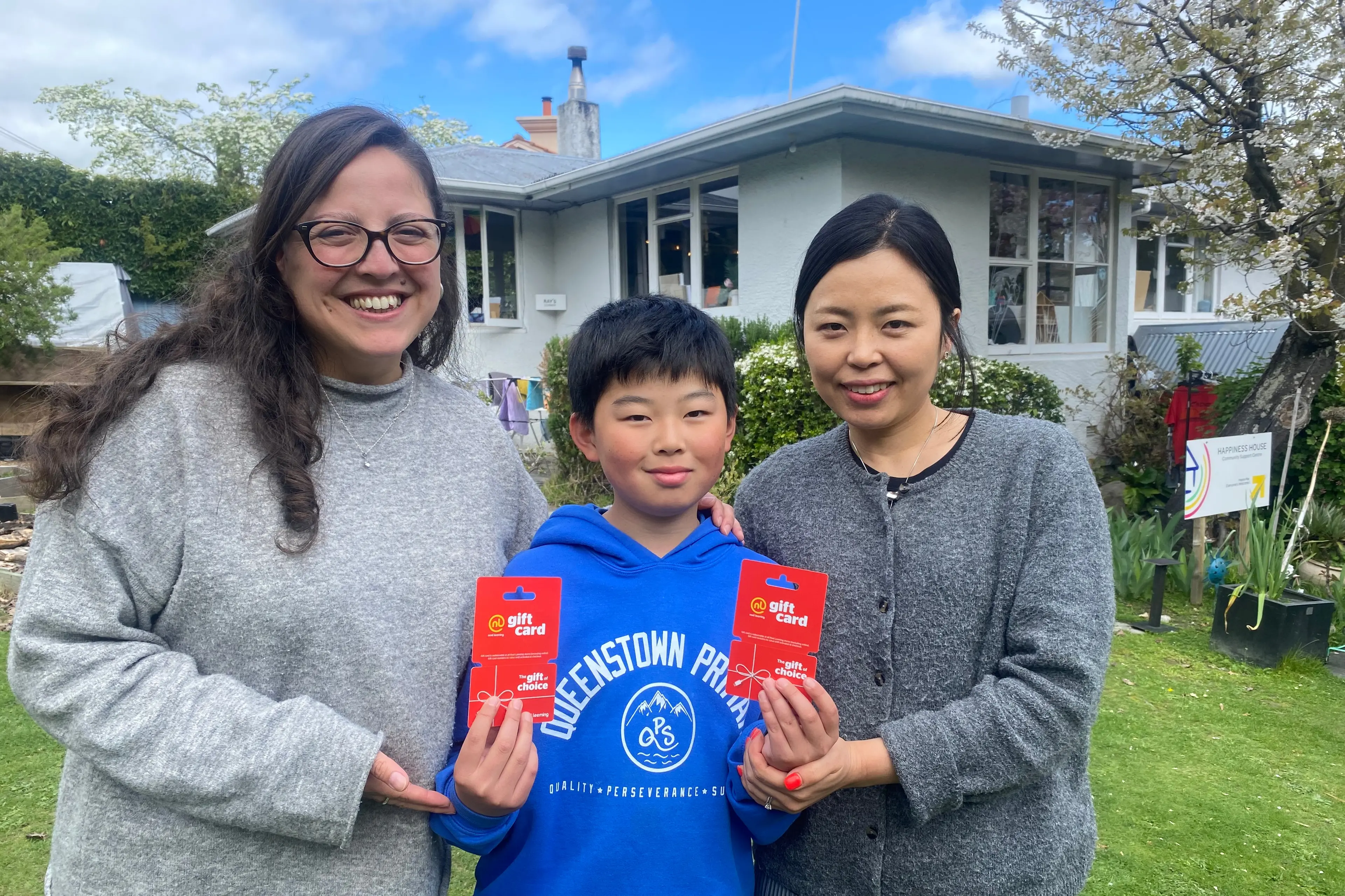 Timely donation: Flanked by Happiness House manager Francisca Retmales, left, and his mum Hana Kim, Yuto Kim displays the Noel Leeming gift cards he\\u2019s donated to the community support centre. Photo: Philip Chandler