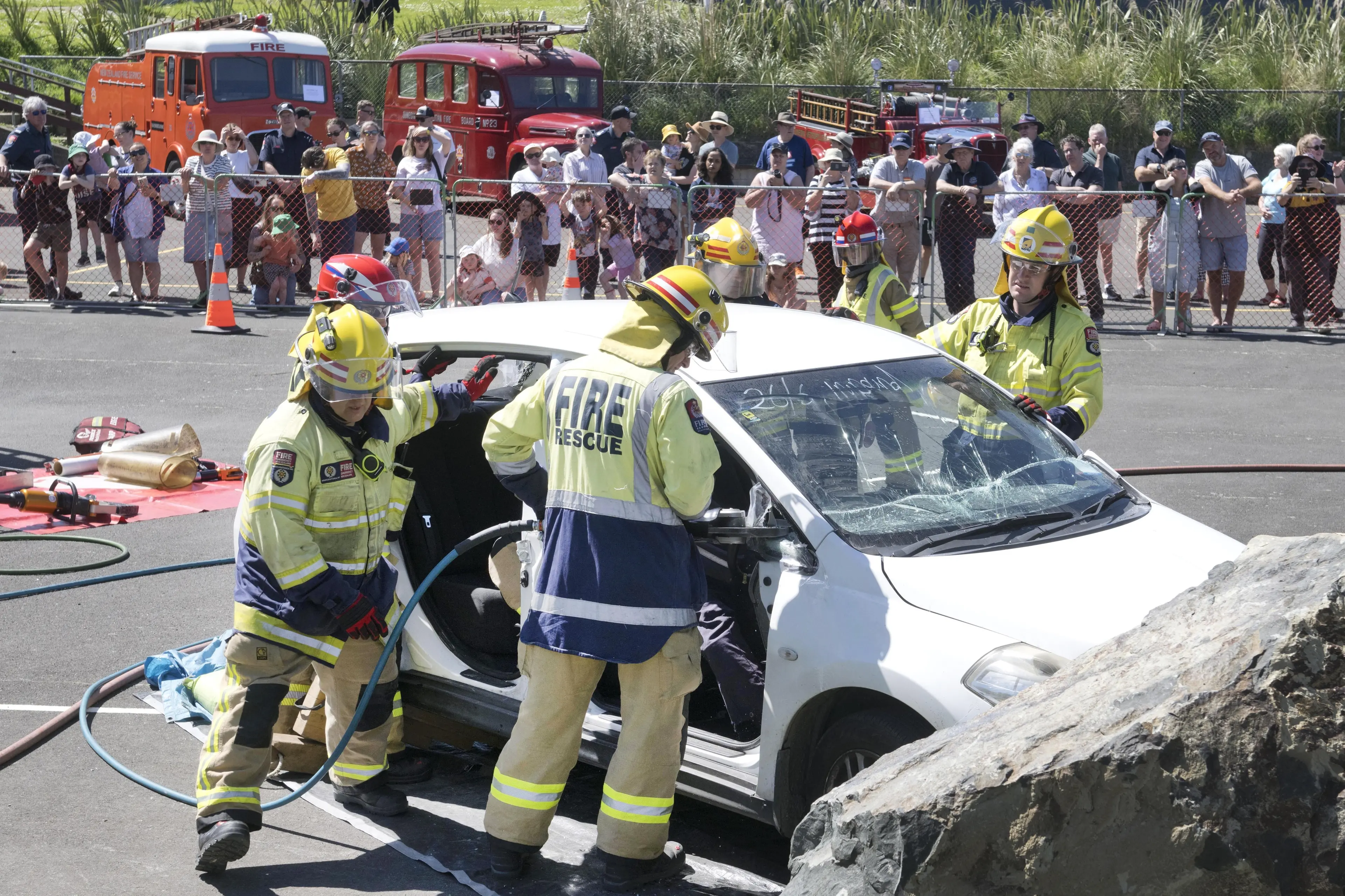 Spectators watch Willowbank and Ravensbourne fire crews extricate a \"patient\" from a car accident during an exercise as part of the Ravensbourne brigade\\'s centenary celebrations on Saturday. Photo: Gerard O\\'Brien