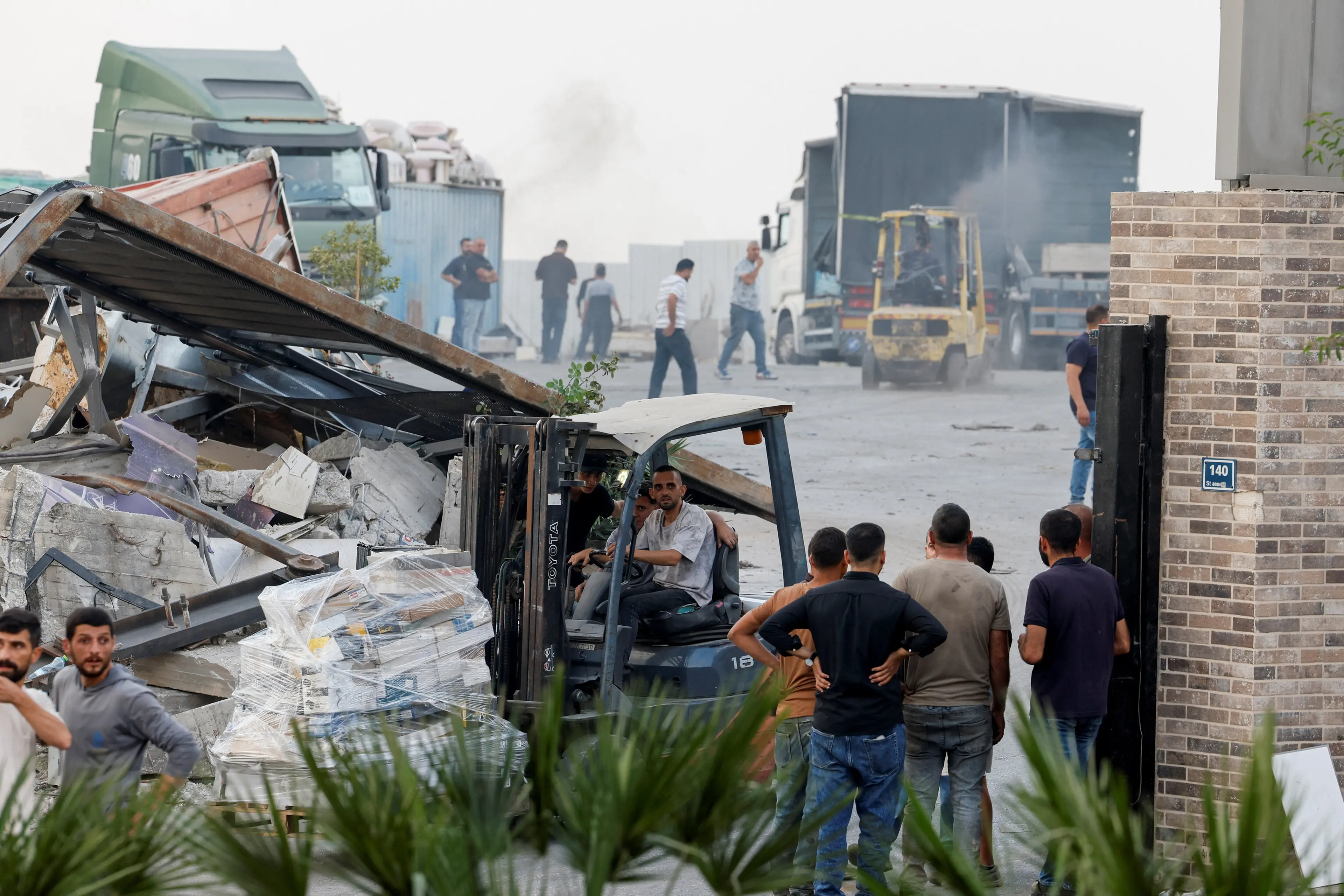 <p>Palestinian volunteers scramble to move goods and supplies of factories which will be demolished by the Israeli army, near the site of a shooting on Friday in Hebron in the Israeli-occupied West Bank. Photo: Reuters </p>\\n