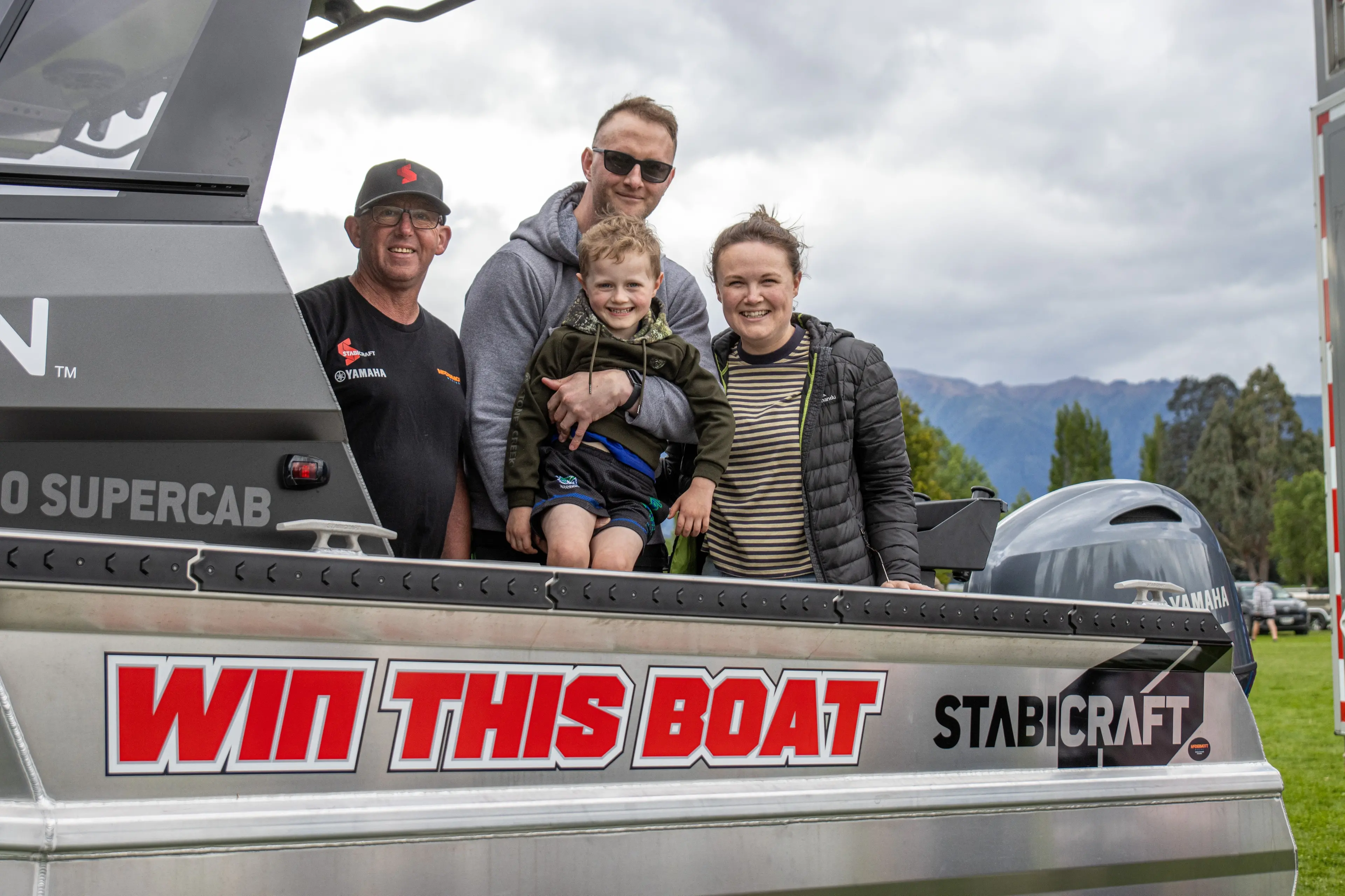 Stabicraft dealership relationship manager Sean McColl welcomed winners of the 2026 Te Anau Community Events Stabicraft Te Anau Manapouri Fishing Classic Jordan McIntosh and Josh Sutherland with her son Lucas, 4, on board their grand first prize - $115,000 Stabicraft 1850 boat package powered by a 115hp Yamaha outboard motor and geared with Garmin fish finder and satellite navigation.  Photo: Wade Parkinson