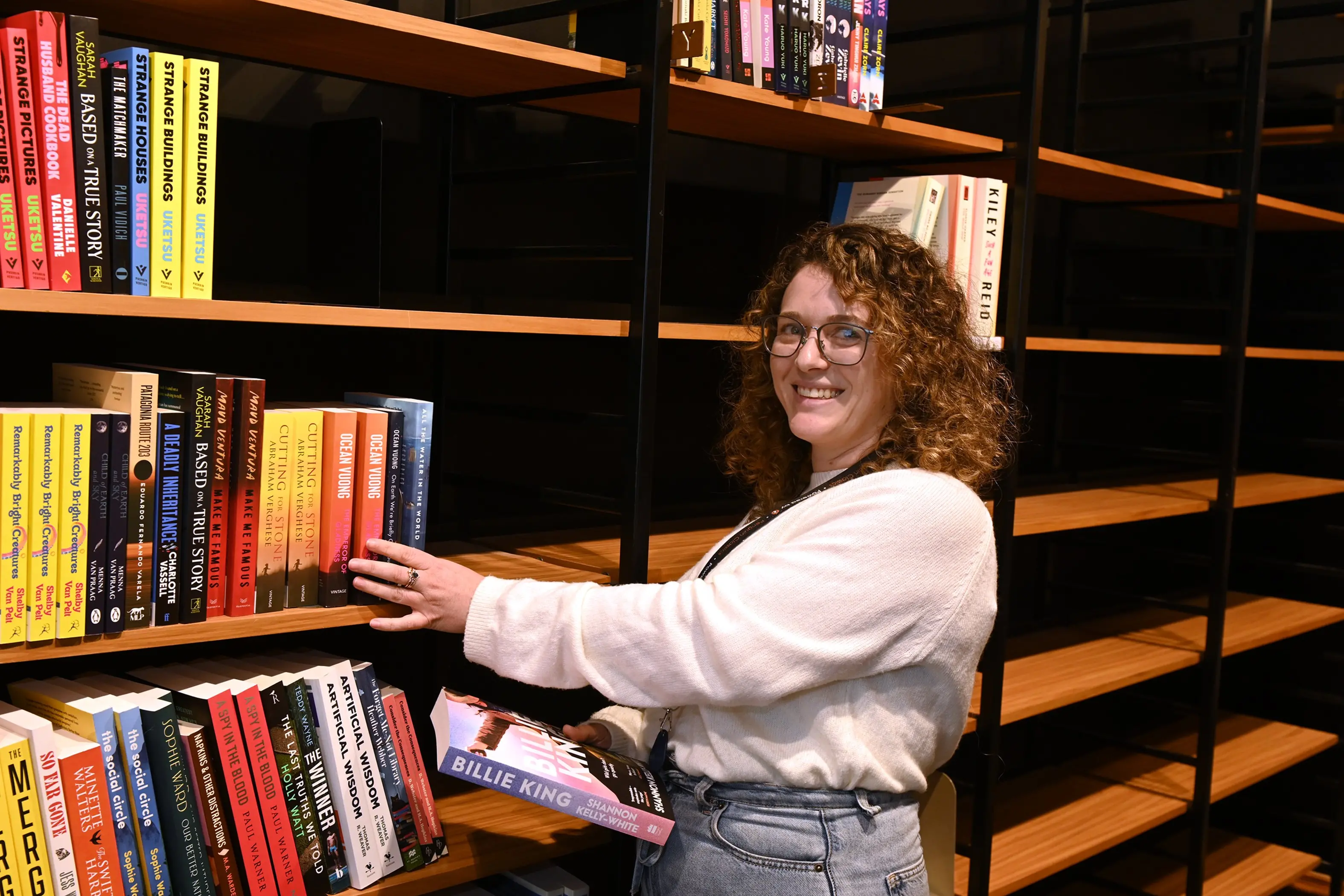 University Book Shop book buyer Jess McKenzie helps to restock the shelves, in preparation for the store\\'s reopening early next month. Photo: Linda Robertson\\u00A0
