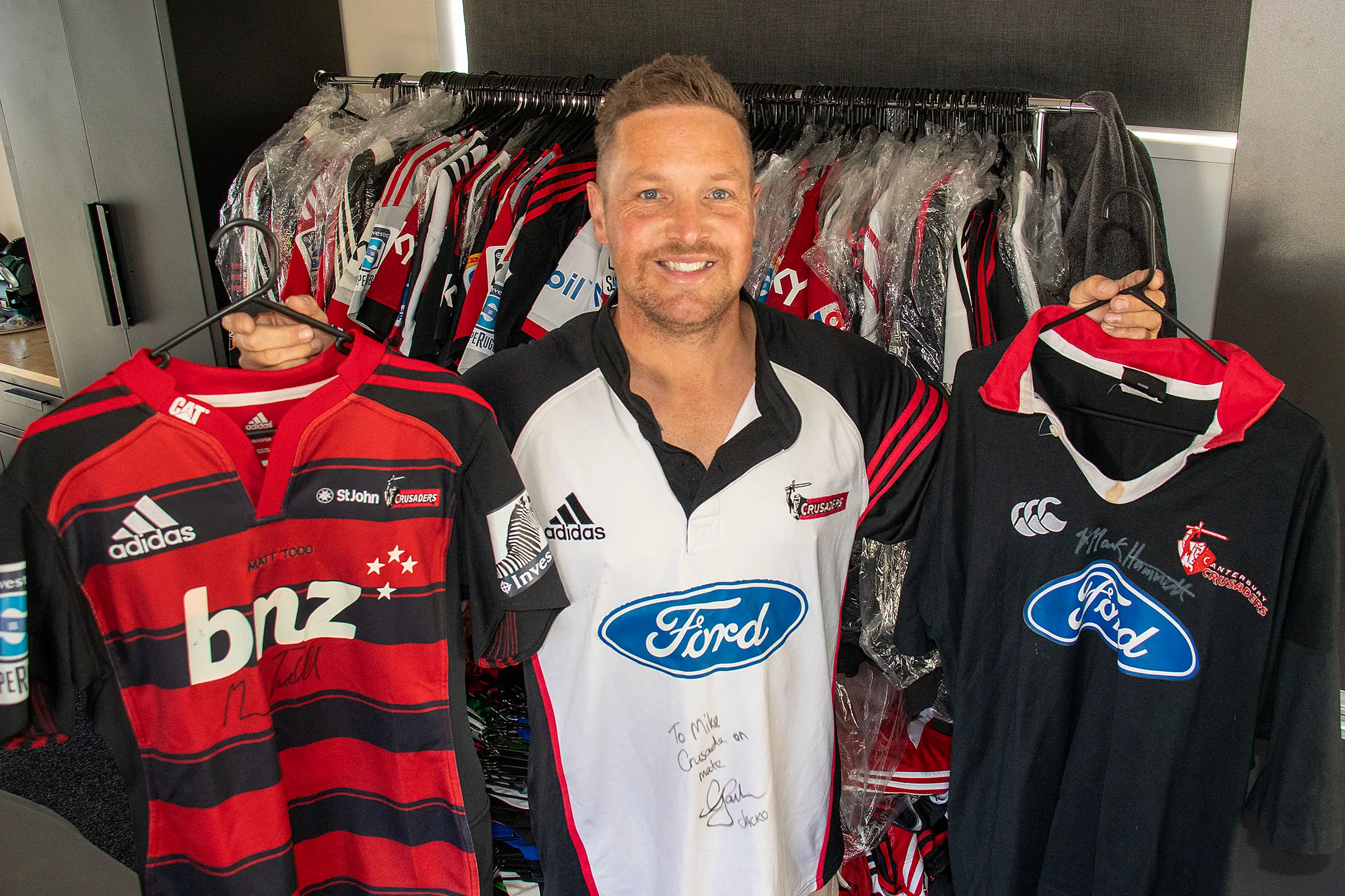 Mike Bensley wearing the first jersey in his collection, given to him by Chris Jack in 2002. He is holding two of his favourites, Matt Todd\\'s one-off jersey in 2012 and Mark Hammett\\'s semi-final kit from 1999. PHOTO: GEOFF SLOAN