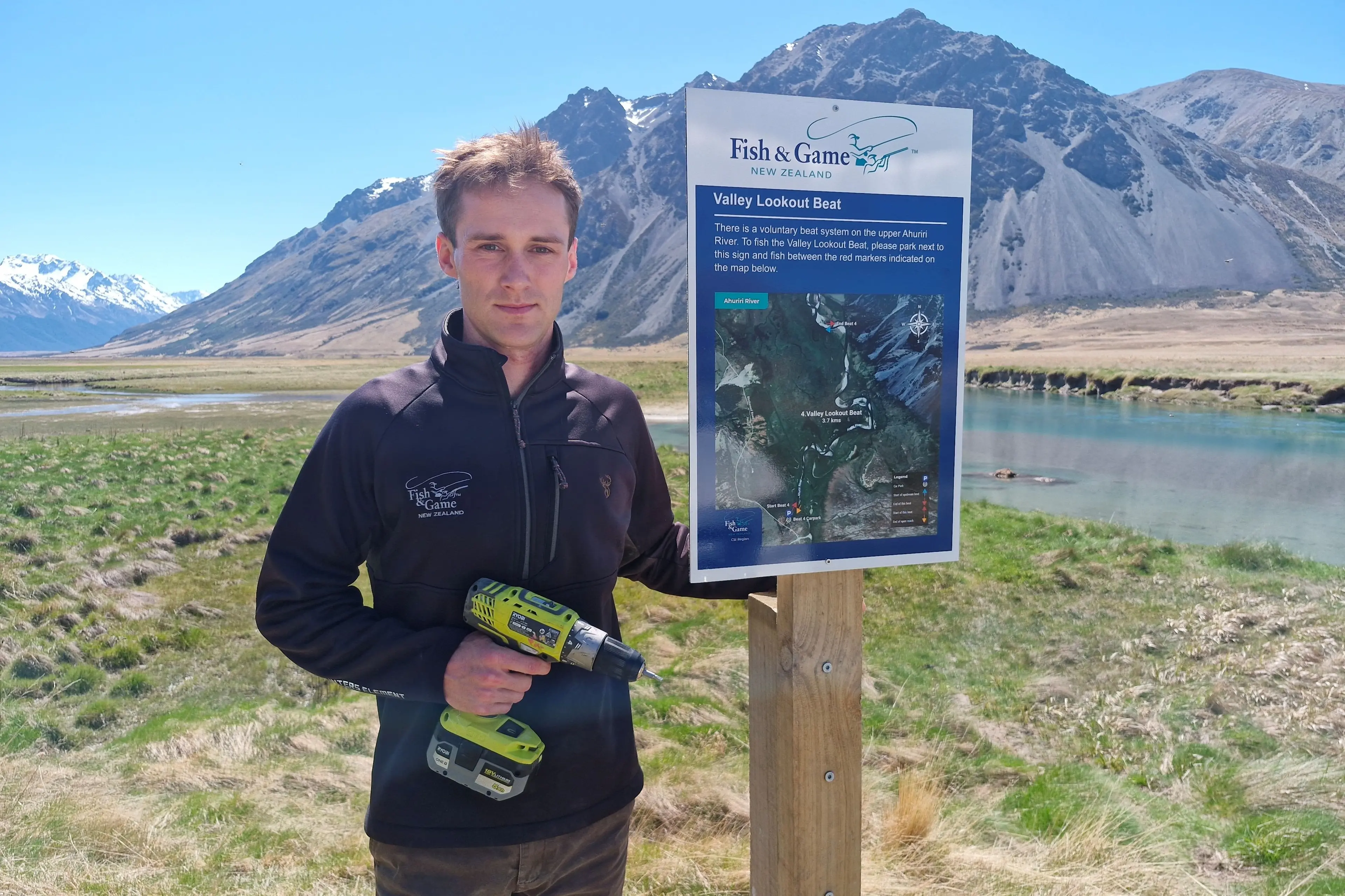Beat signage being installed by Fish & Game officer Blake Harper at the upper Ahuriri River ahead of opening day of the high-country fishing season on November 7. Photo: Rhys Adams/Fish & Game.